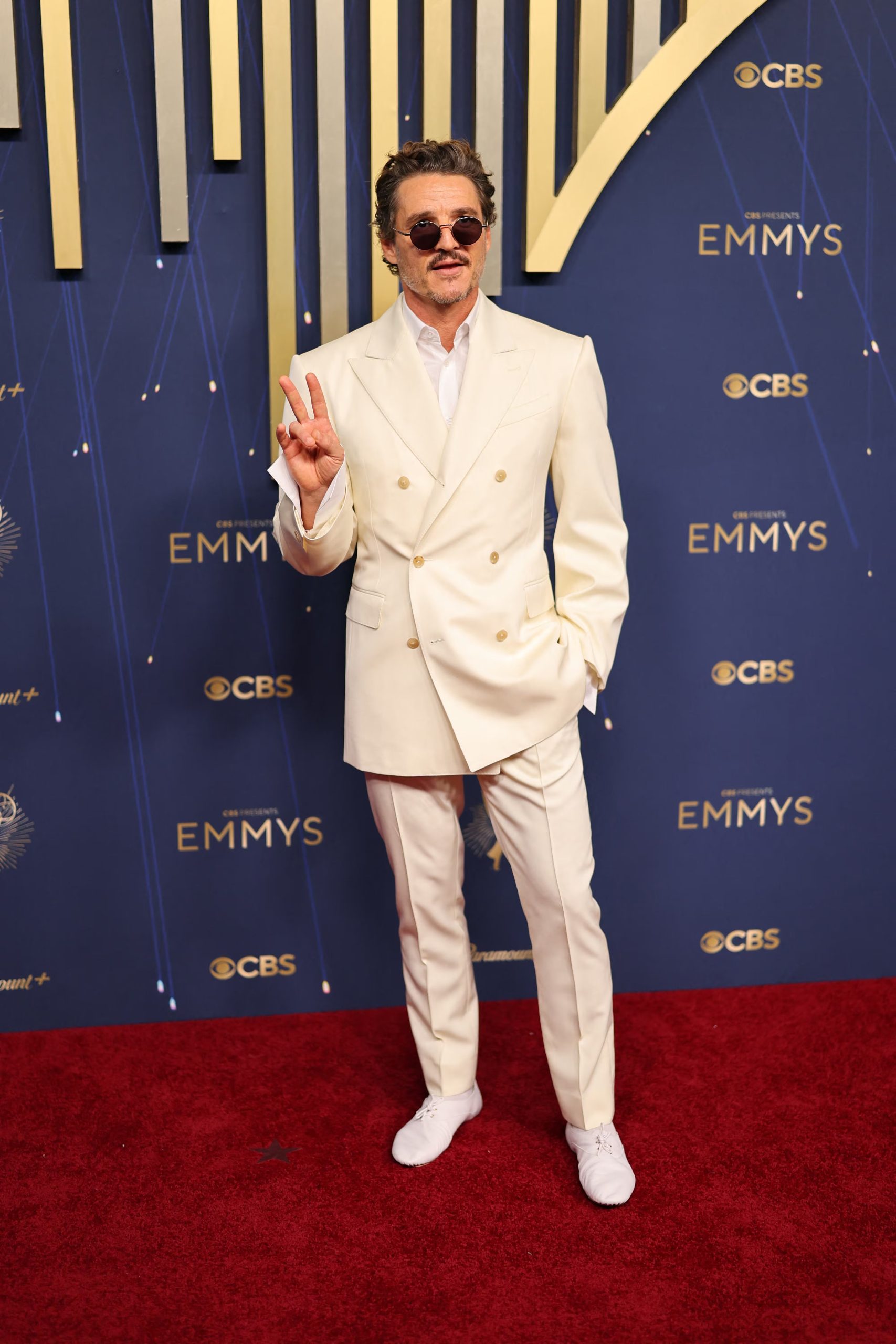 Pedro Pascal combina un ambo cruzado blanco roto de Celine con avíos dorados

