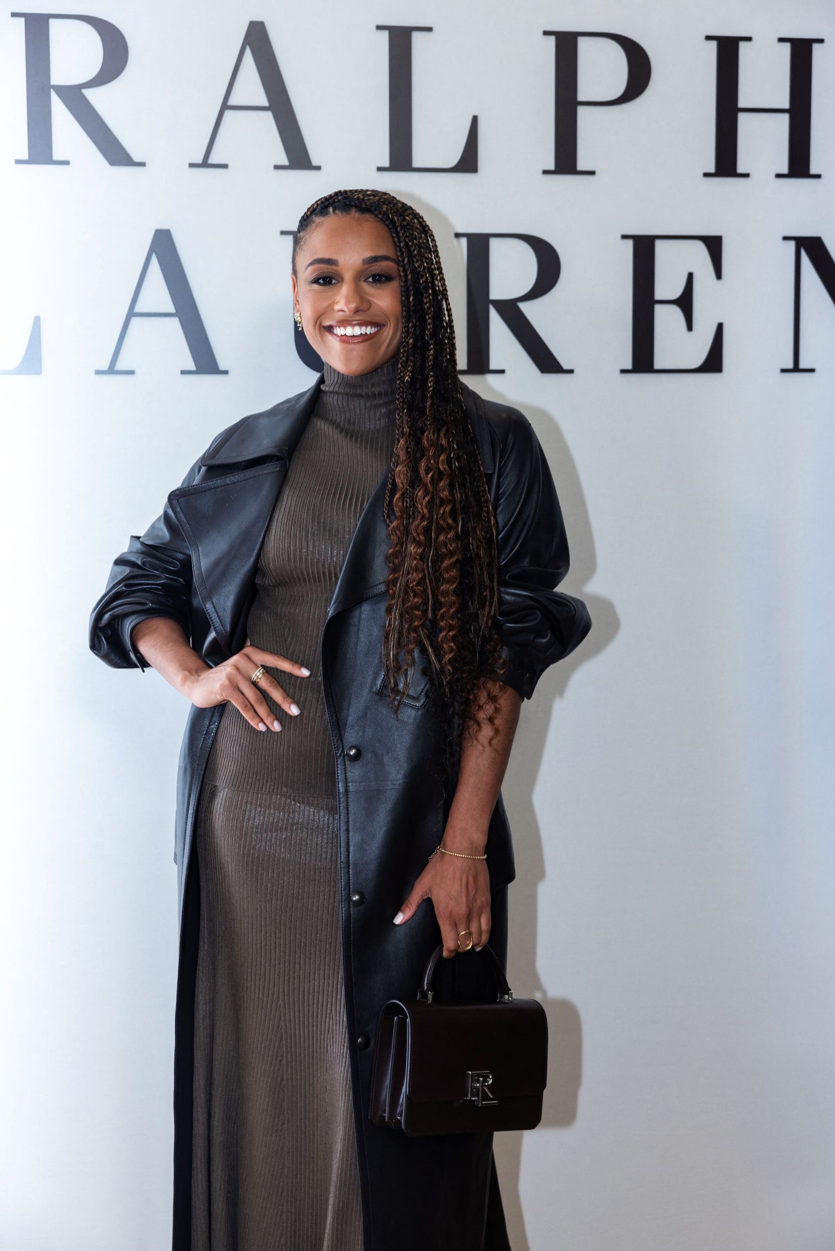 Ariana DeBose llevó un trench coat de cuero negro sobre un suéter de cuello alto y falda midi (REUTERS/Caitlin Ochs)