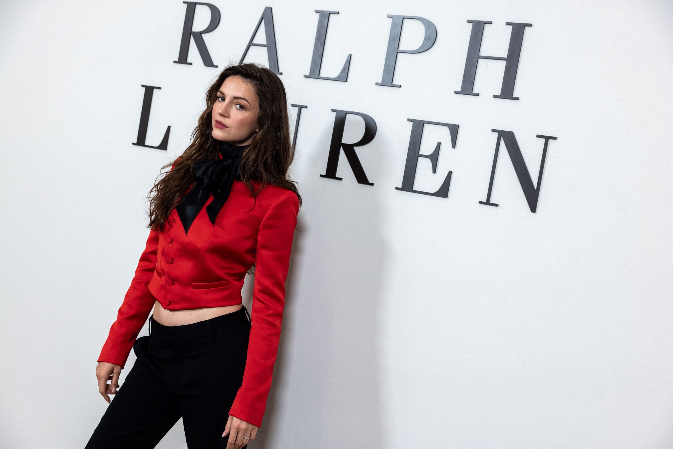 Ella Hunt sumó color a la primera fila con una chaqueta corta de esmoquin en rojo intenso (REUTERS/Caitlin Ochs)