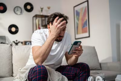 Adulto dándose cuenta que acaba de caer en un fraude a través de WhatsApp. (EFE)