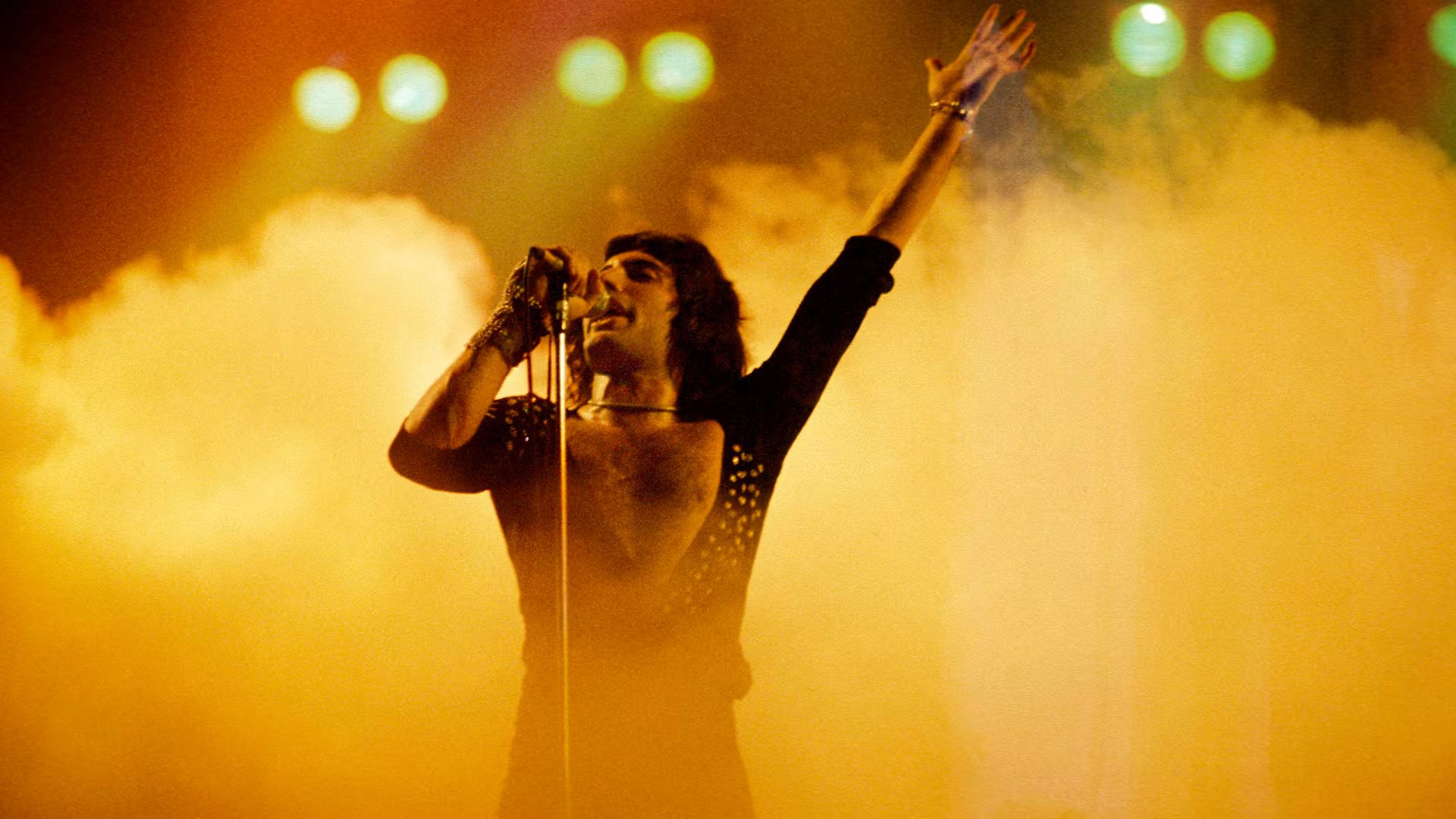 El vestuario negro con acabados lustrosos resaltaba la figura en los movimientos de Mercury sobre la tarima (Fin Costello/Redferns)