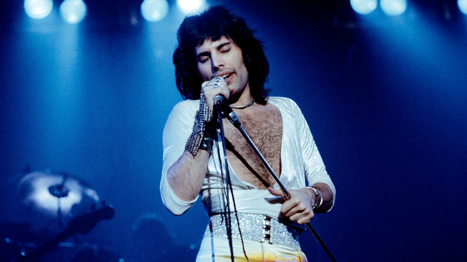 El cantante utilizaba chaquetas y pantalones blancos para resaltar bajo la iluminación intensa del escenario (Fin Costello/Redferns)