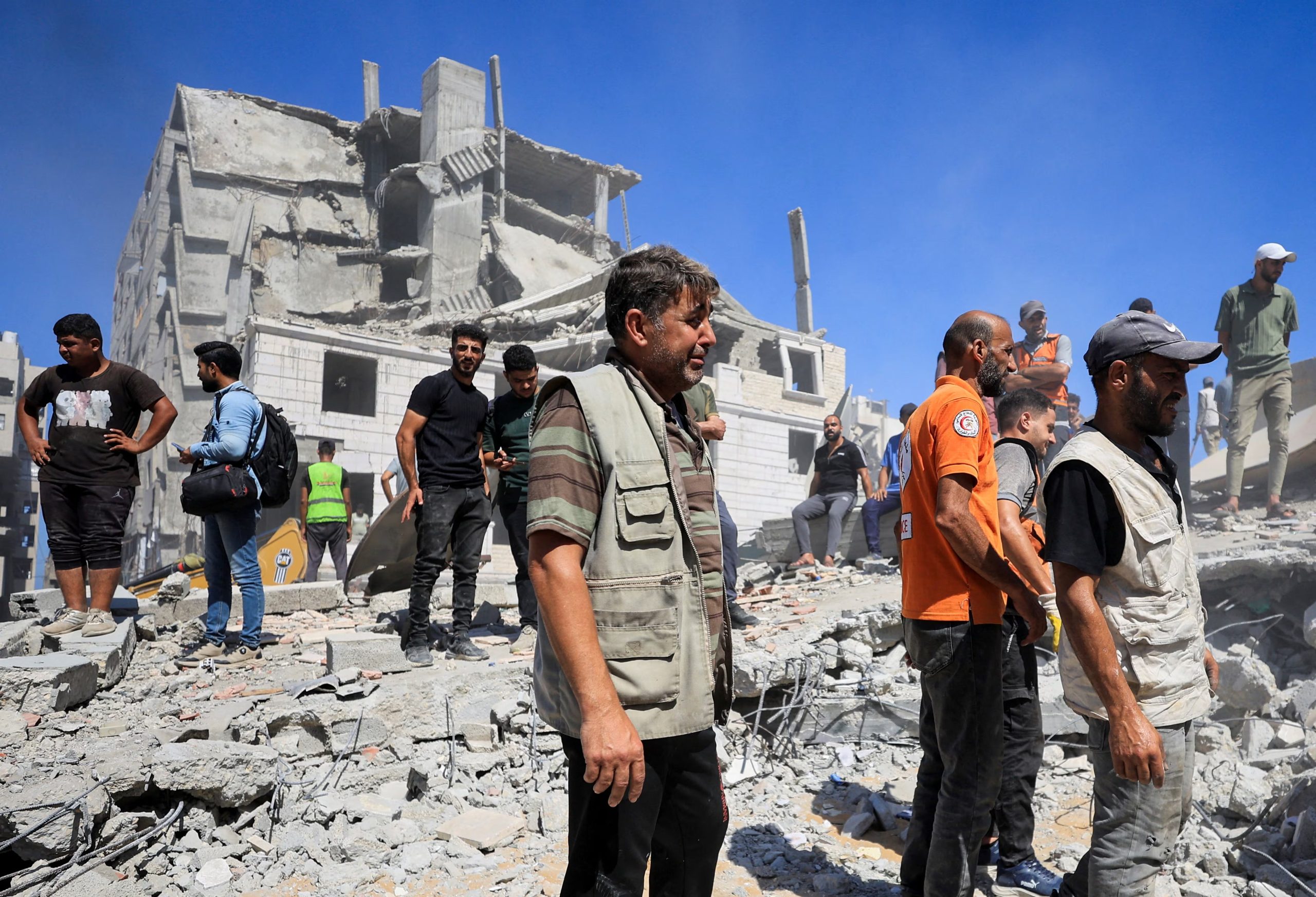 Vecinos se reúnen mientras trabajadores de Defensa Civil intentan rescatar a personas atrapadas bajo los escombros de un edificio residencial, dañado en un ataque israelí durante la guerra y que colapsó este miércoles, en Ciudad de Gaza, el 16 de septiembre de 2026 (REUTERS/Dawoud Abu Alkas)
