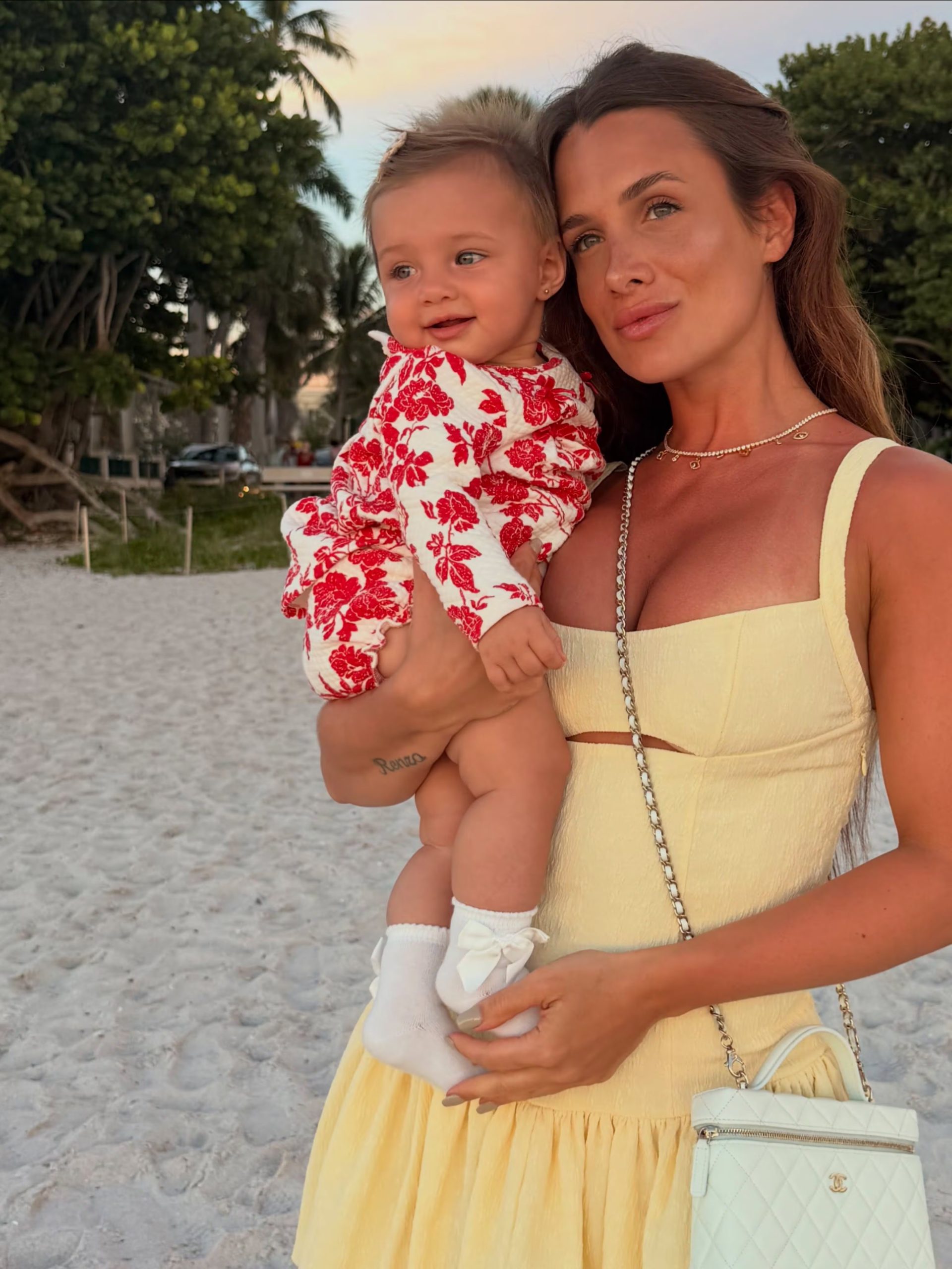 Aitana lució un conjunto blanco con flores rojas mientras posaba junto a su madre frente a la playa