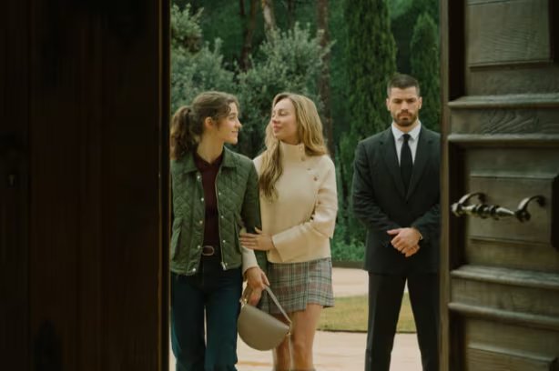 Las protagonistas de la novela Marfil de Mercedes Ron caminan junto a un hombre en un entorno ajardinado. (Prime Video)