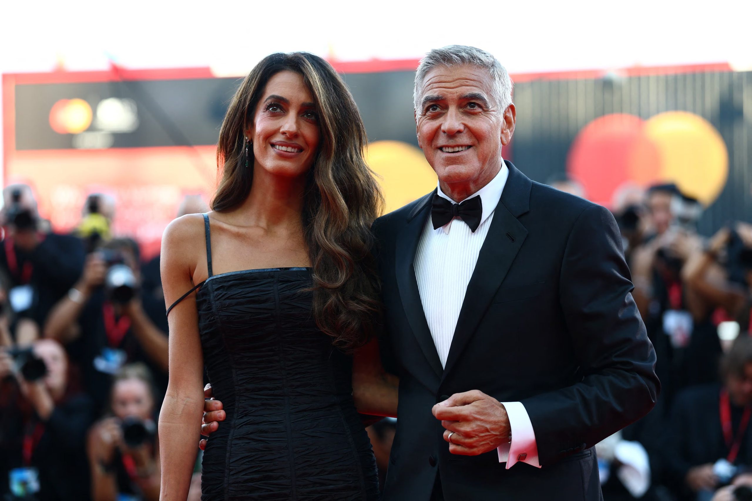 George Clooney junto a su esposa Amal Clooney posando en la alfombra roja antes de recibir en Venecia un premio a toda su carrera. REUTERS/Yves Herman