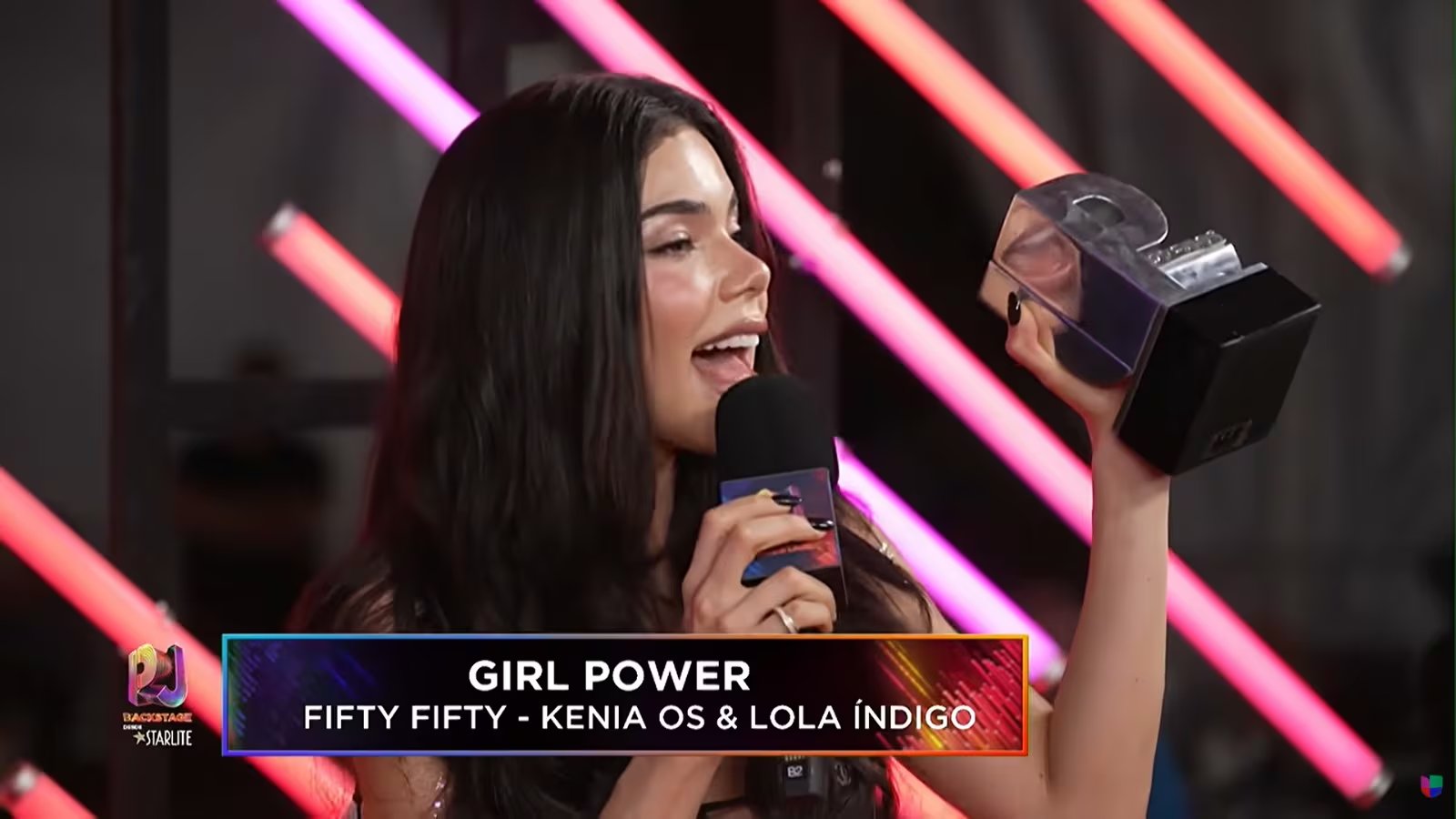 La cantante mexicana Kenia Os sostiene un galardón y habla por un micrófono tras ser premiada en la categoría Girl Power por la canción Fifty Fifty. (Captura de Pantalla/Univisión Youtube)