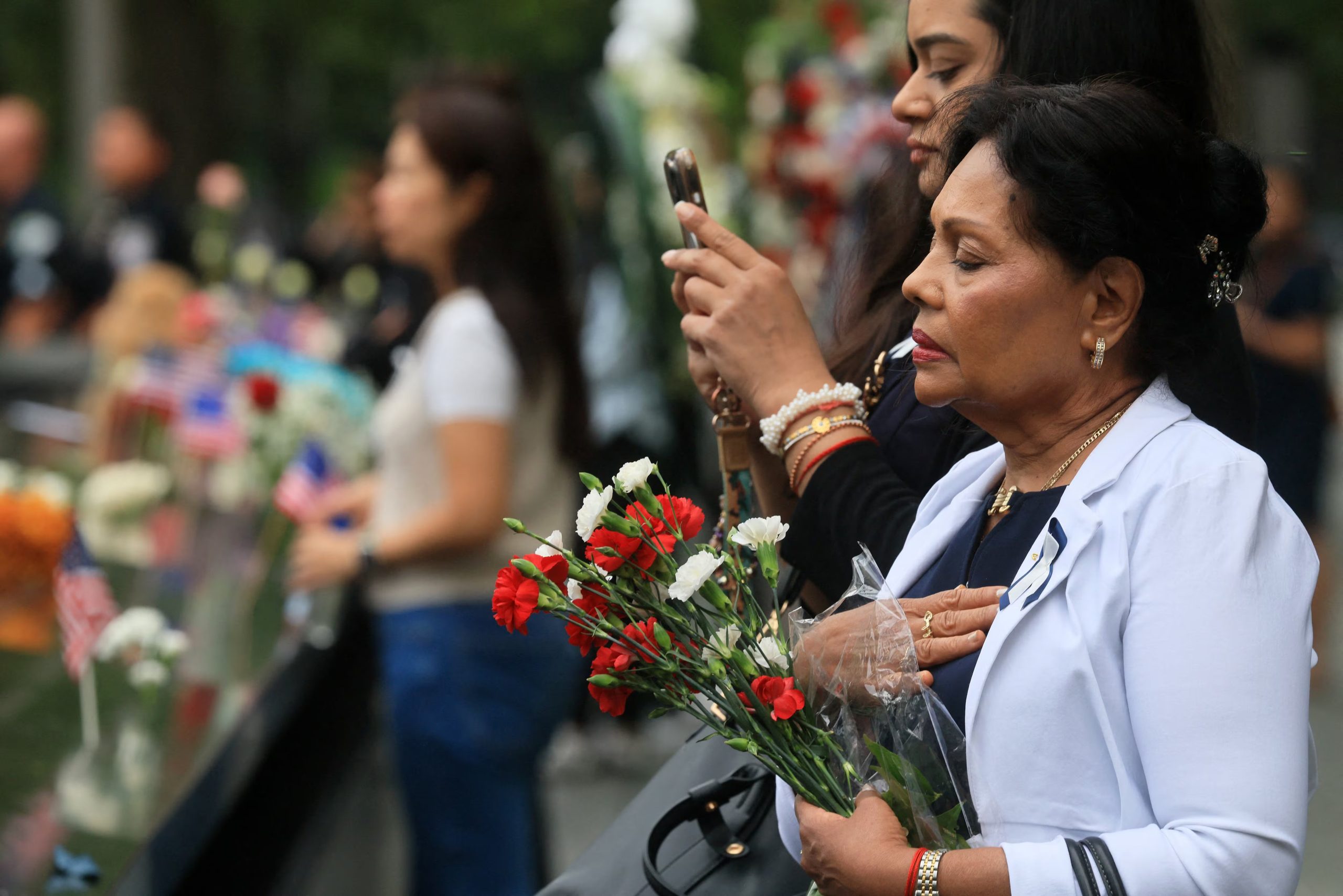 Varias personas se congregan en el monumento conmemorativo durante una ceremonia que celebra el 25 aniversario de los atentados del 11 de septiembre de 2001 (Spencer Platt/Pool vía REUTERS)