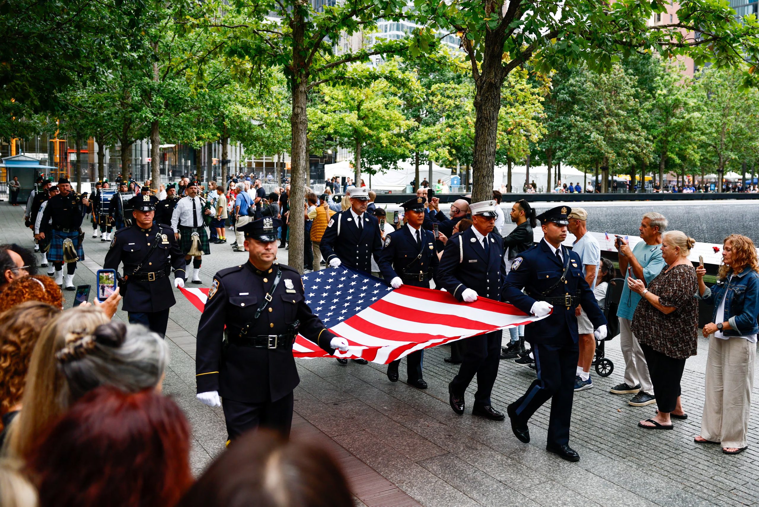 Efectivos portan una bandera estadounidense junto a los estanques reflectantes del Memorial del 11-S (REUTERS/Jeenah Moon/Pool)
