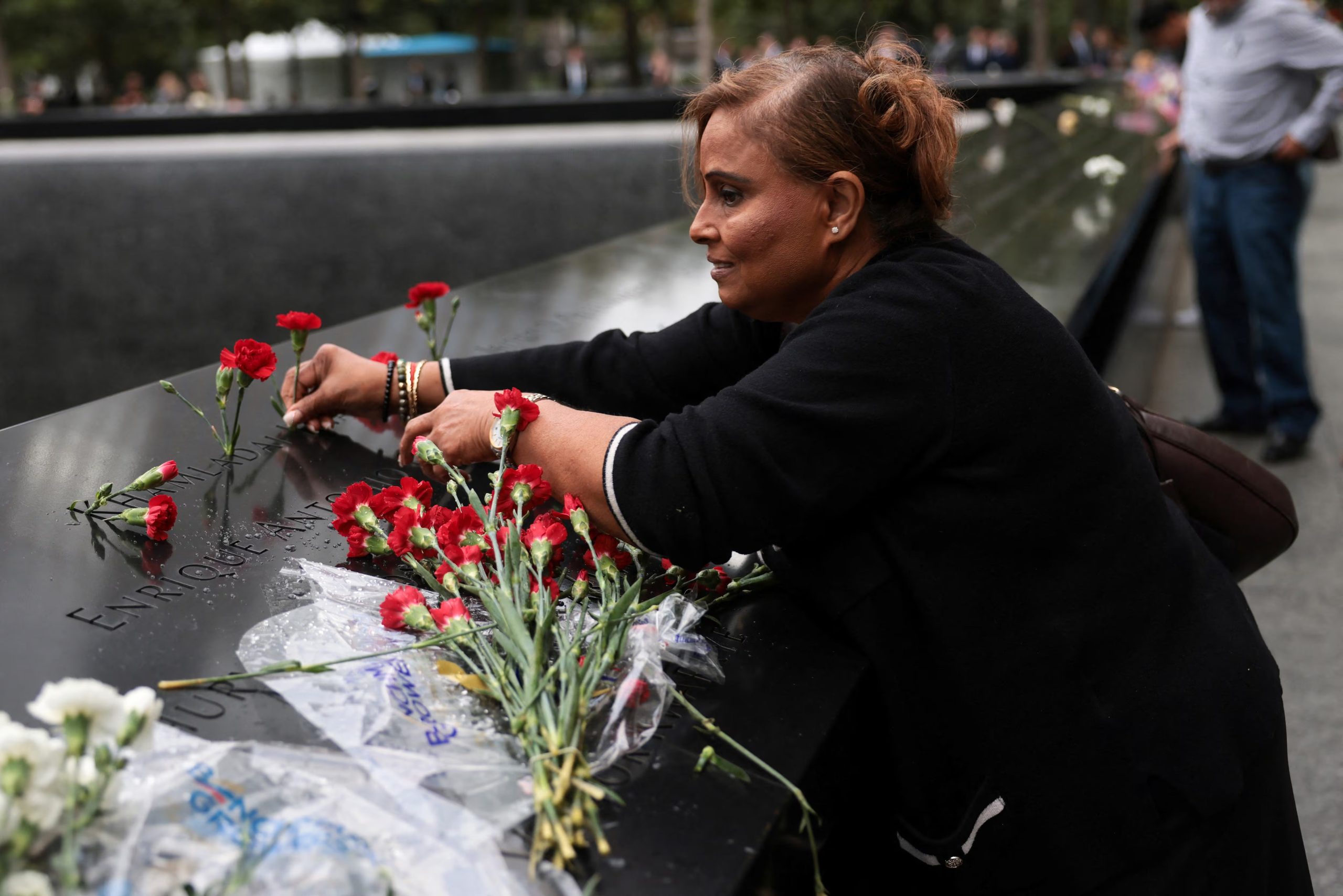 Pam Jagdarry deposita flores en el monumento conmemorativo (Spencer Platt/Pool vía REUTERS)
