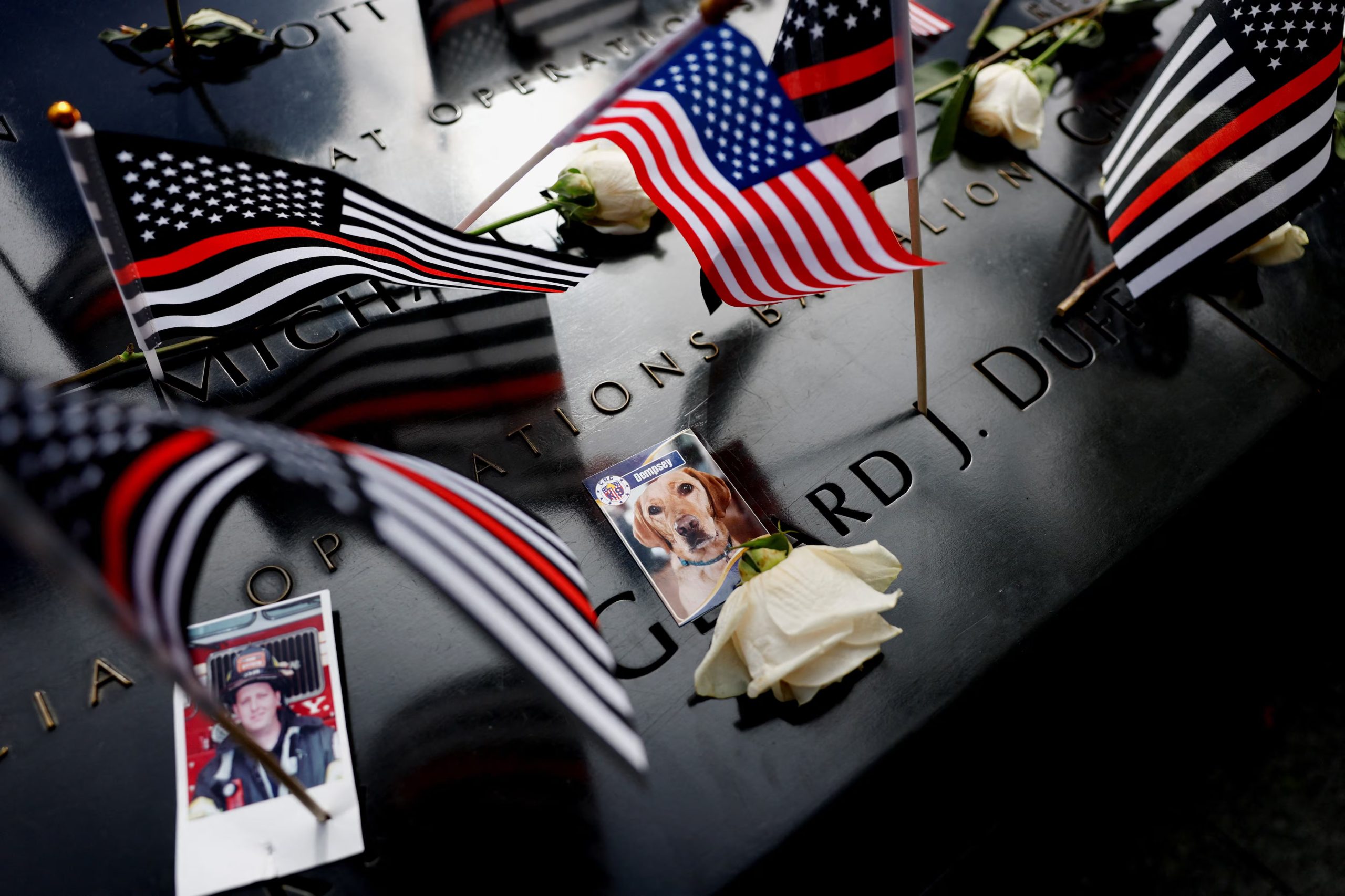 Banderas, flores y fotografías se colocan sobre los nombres de las víctimas en el Memorial del 11-S durante una ceremonia que conmemora el 25 aniversario de los ataques del 11 de septiembre de 2001 contra el World Trade Center, en la ciudad de Nueva York, EE. UU., 11 de septiembre de 2026. REUTERS/Brendan McDermid