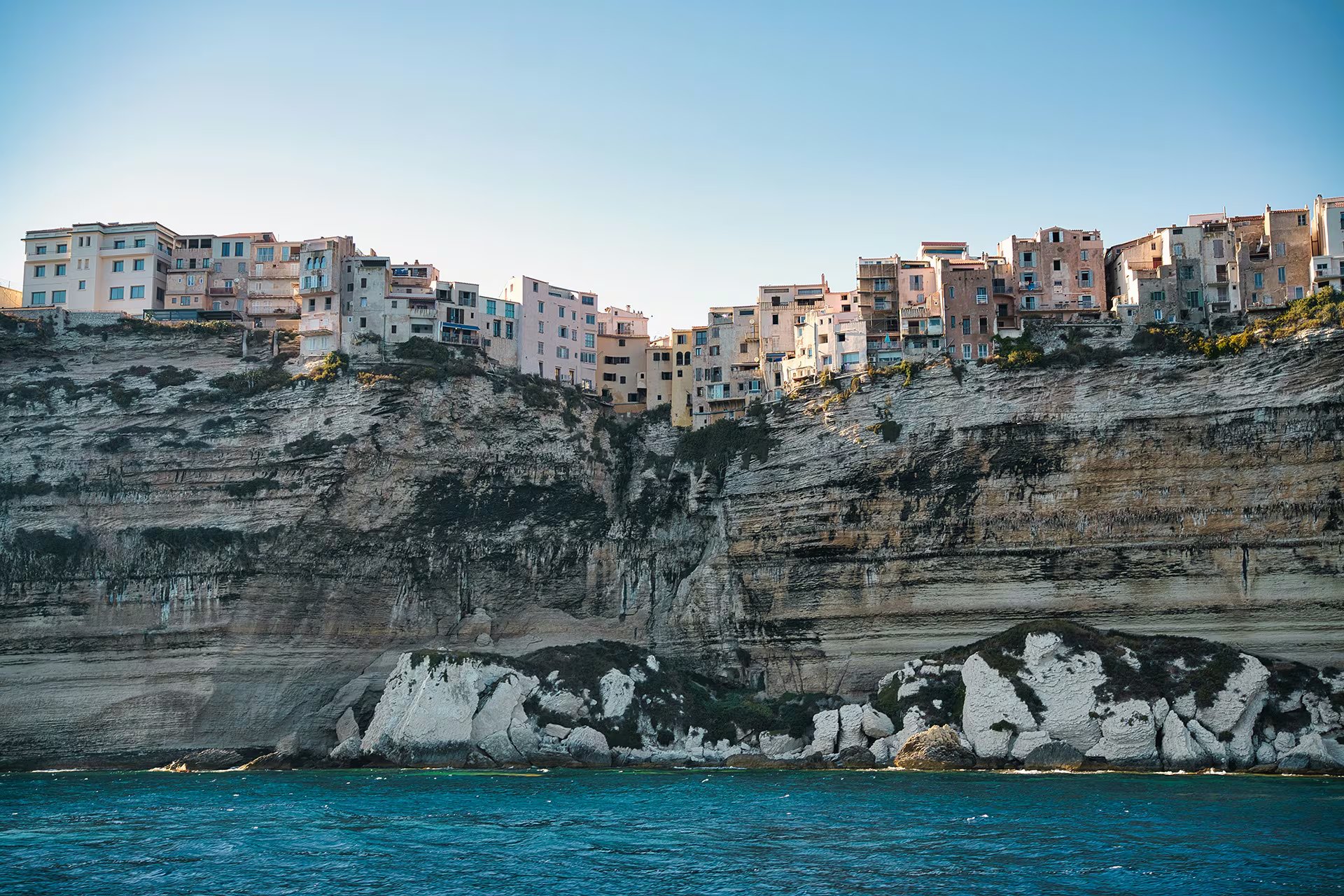 Las casas de la ciudadela de Bonifacio se alinean sobre un acantilado de piedra caliza blanca, erosionado durante siglos por el mar Mediterráneo (Unsplash)