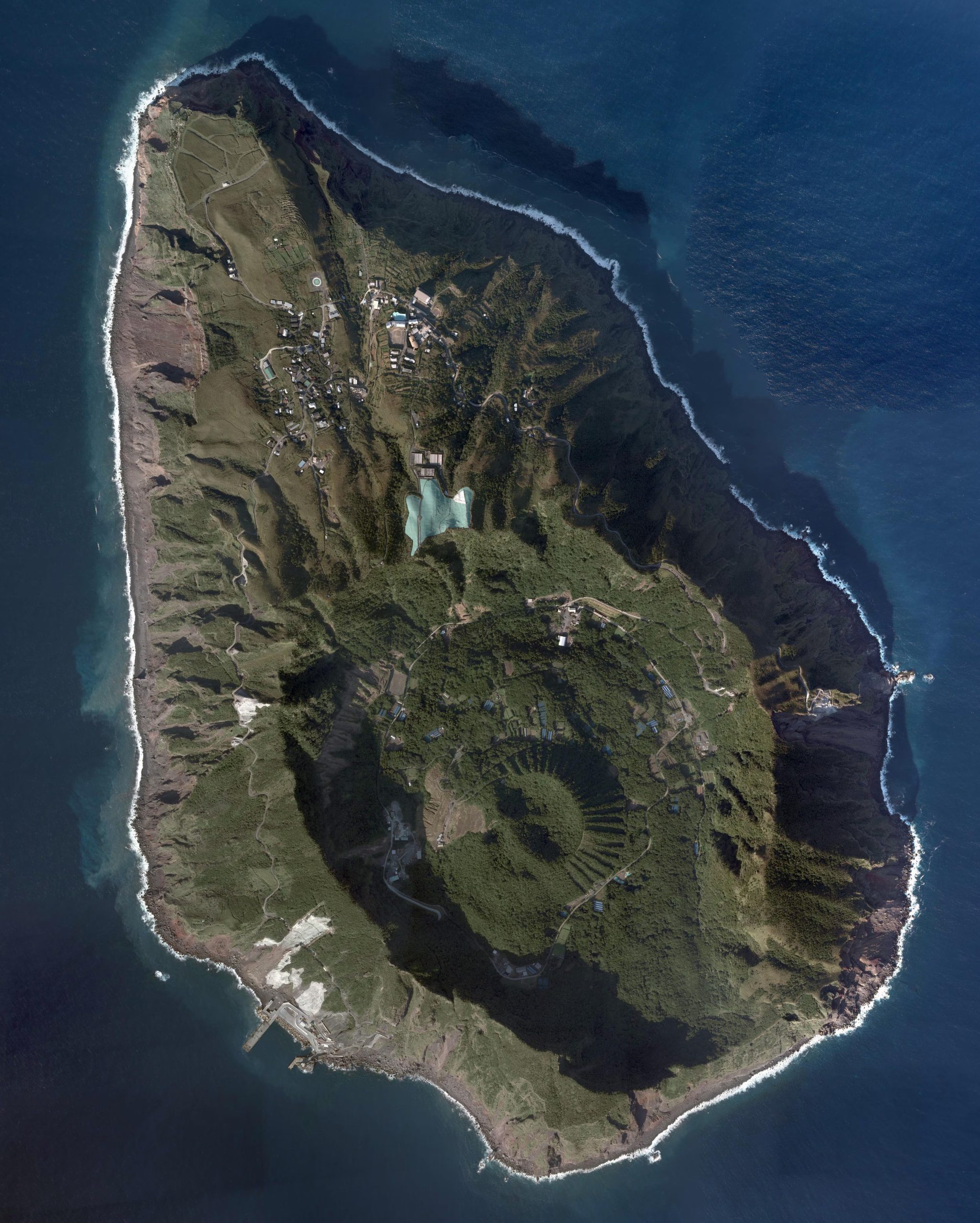 La isla de Aogashima alberga una comunidad que vive entre dos cráteres, rodeada por murallas de basalto y vegetación densa (Wikipedia)