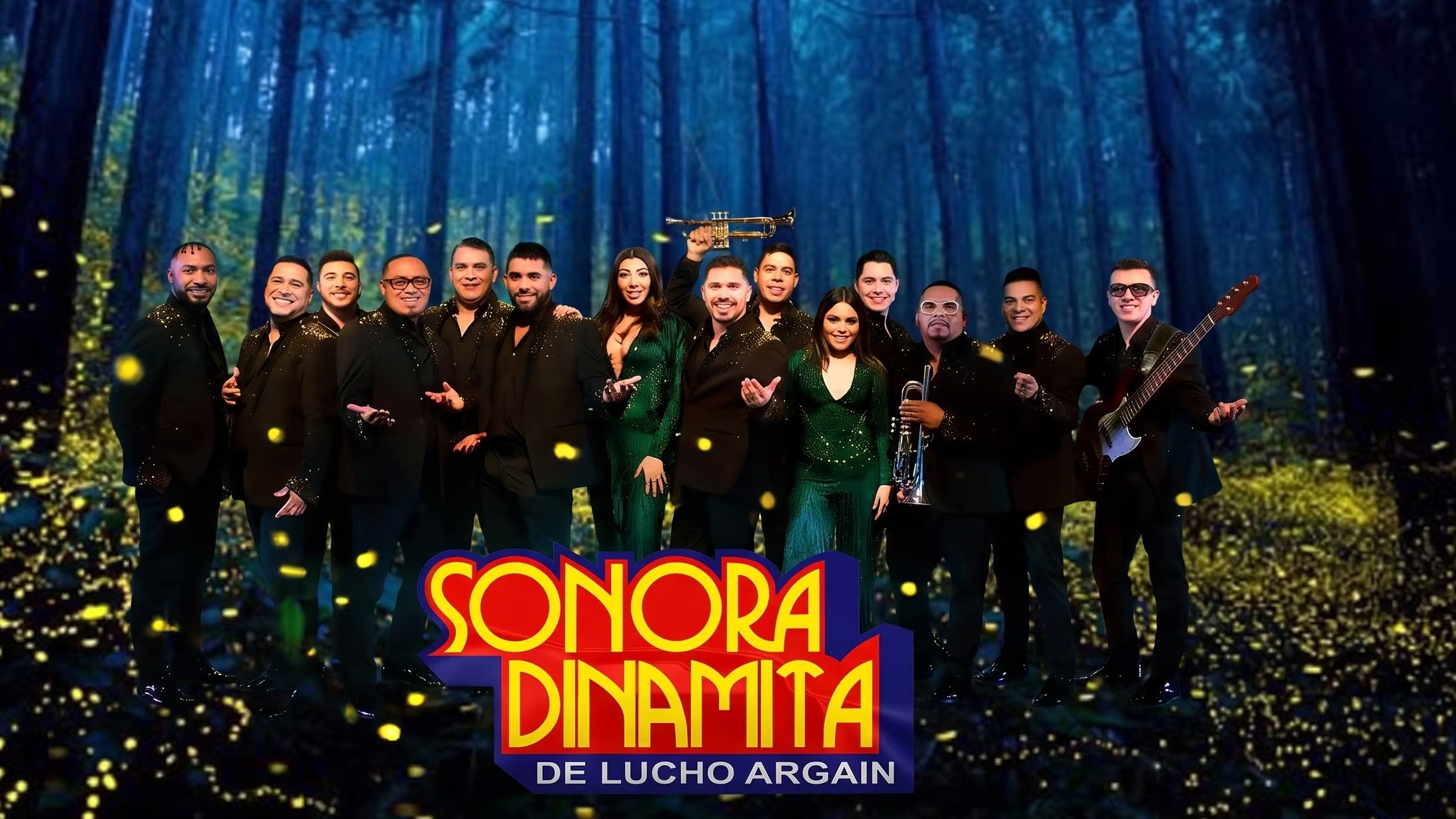 La agrupación musical Sonora Dinamita de Lucho Argaín posa con sus invitados especiales en un bosque oscuro con puntos de luz, junto a su logo distintivo. (Imagen Ilustrativa Infobae)