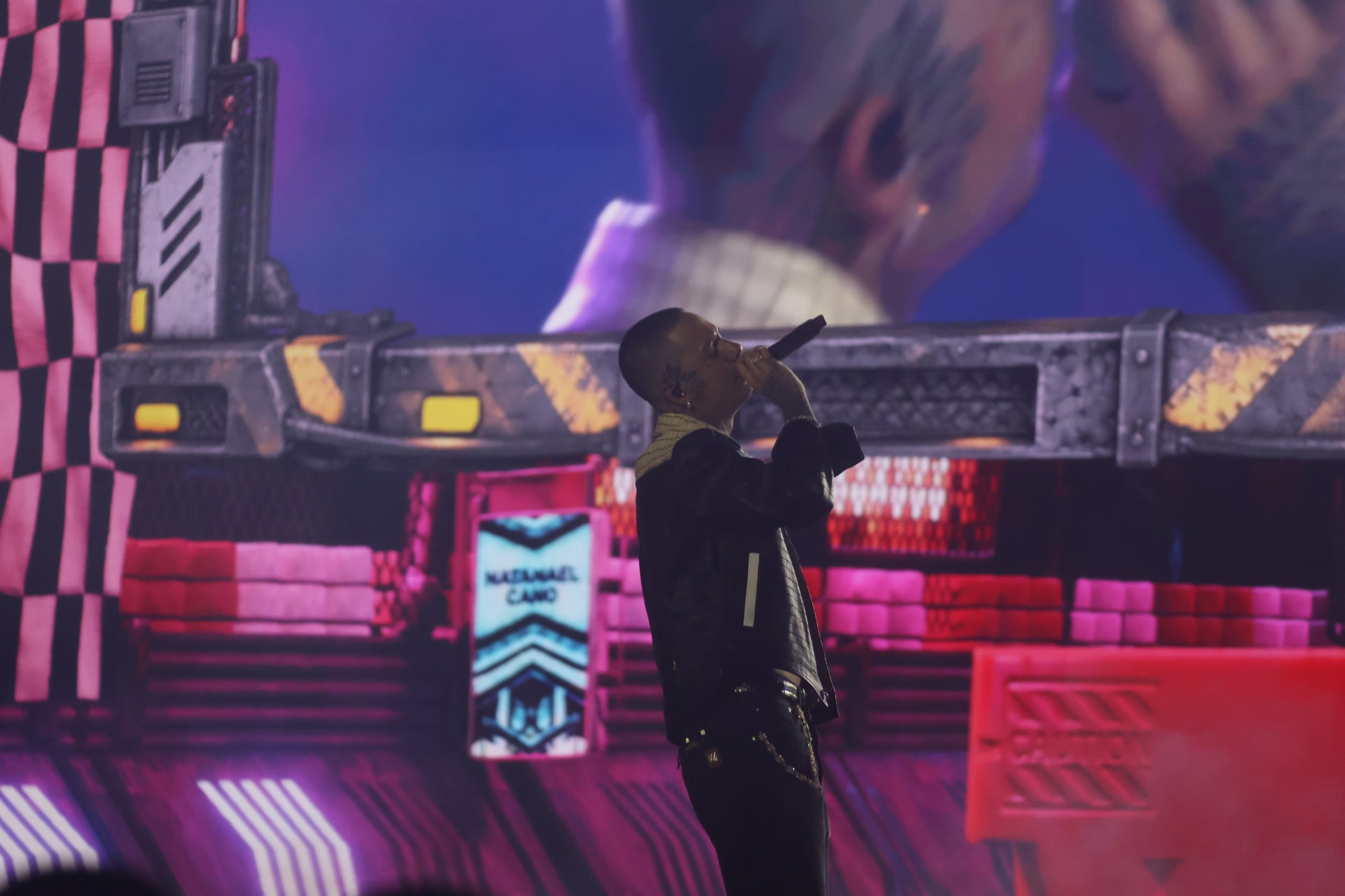 El cantante Natanael Cano interpreta un tema musical durante una actuación en vivo frente a un escenario decorado con pantallas e iluminación. (Selene Miranda/Infobae México)