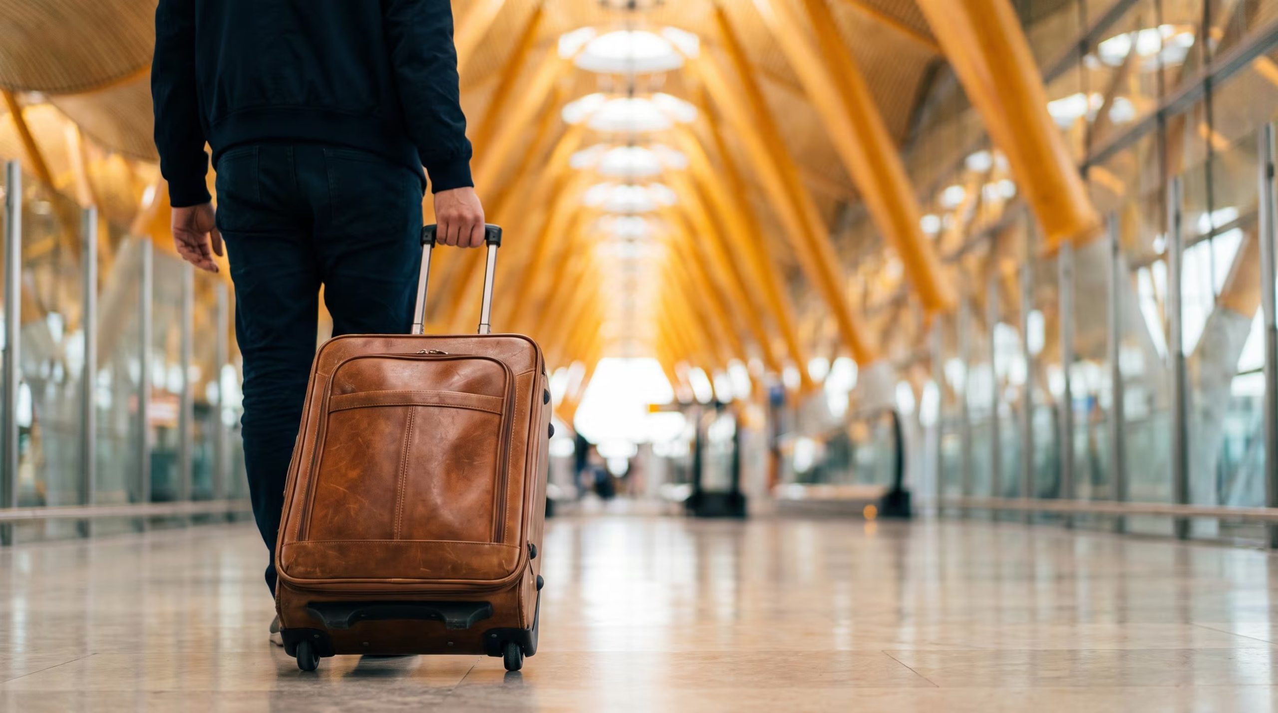 Un pasajero camina por la terminal de un aeropuerto mientras traslada su equipaje de mano. (Imagen Ilustrativa Infobae)
