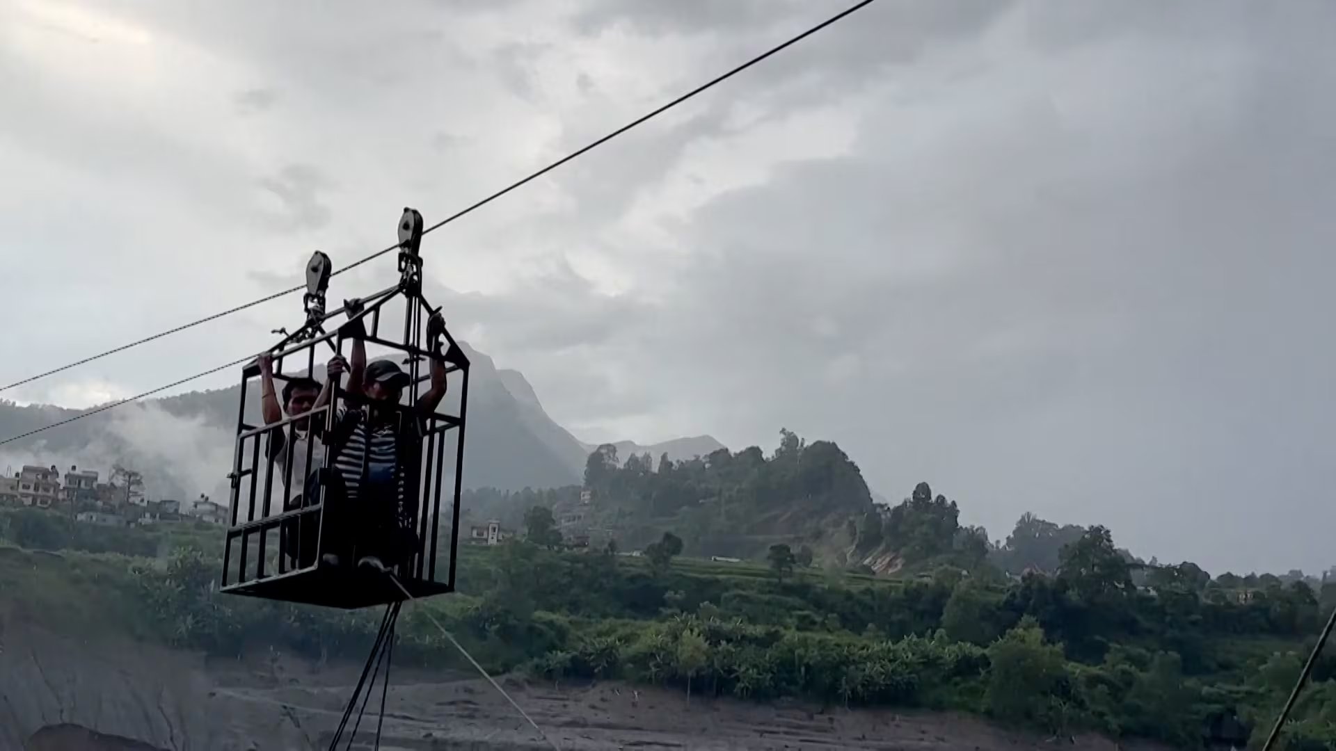 Habitantes de aldeas aisladas cruzan el río Trishuli en tirolesa tras la destrucción de los puentes por las inundaciones en Nepal (Captura de video)