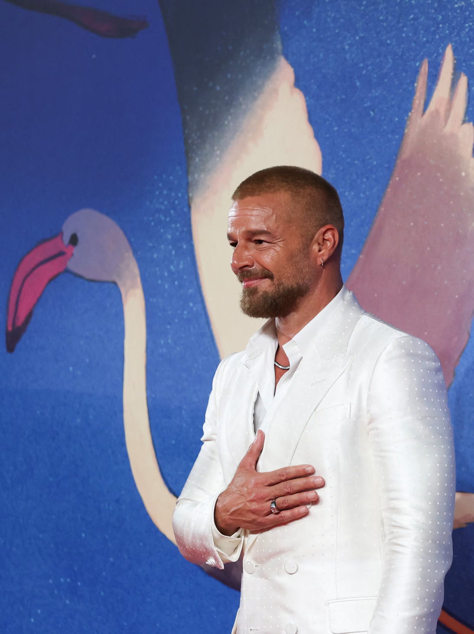 Una chaqueta blanca satinada se convierte en el centro visual de su look para la alfombra roja (REUTERS/Yves Herman)
