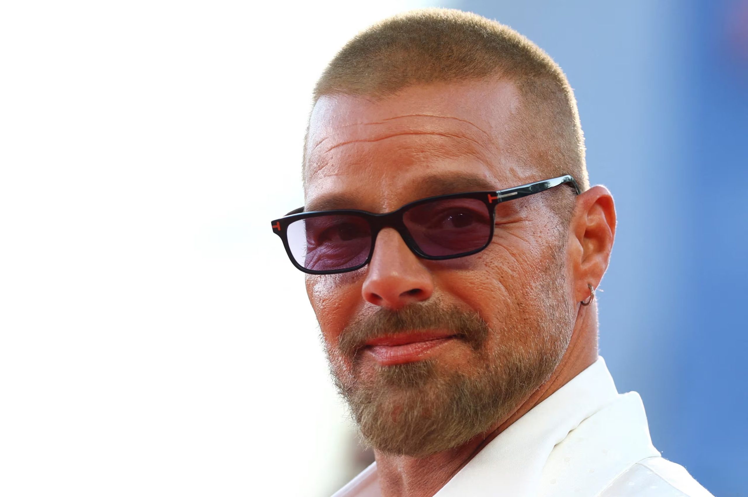 En la alfombra roja de Venecia, Ricky Martin eligió una chaqueta blanca satinada con relieve sutil y pantalón negro recto (REUTERS/Yves Herman)