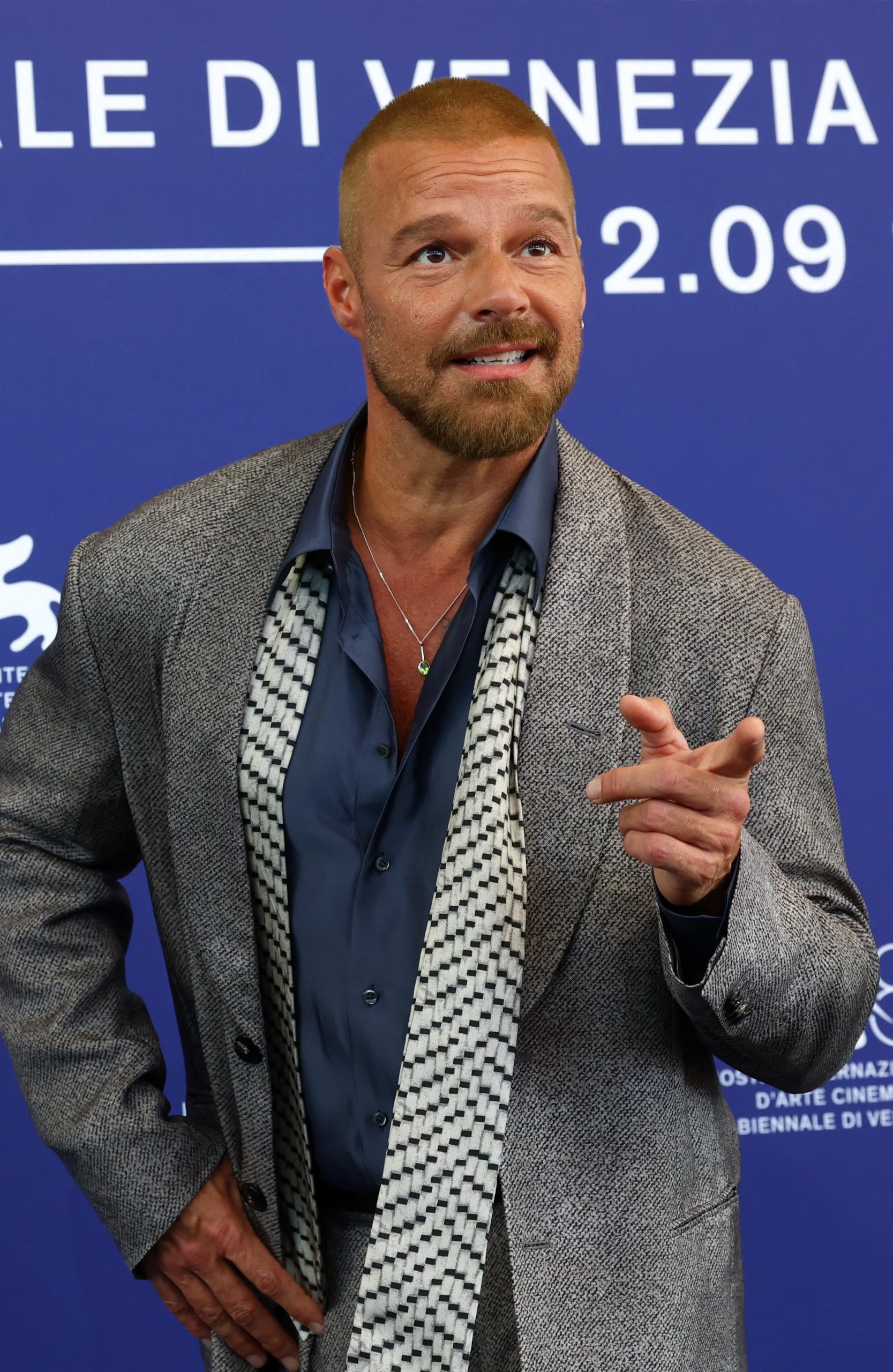 El segundo look de Ricky Martin incluyó una camisa azul oscuro sin corbata y un pañuelo blanco y negro con diseño geométrico (REUTERS/Yves Herman)