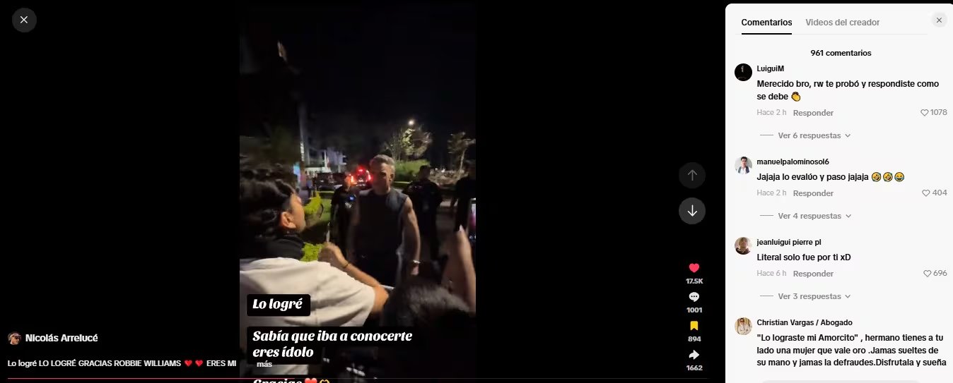 El cantante británico Robbie Williams se acerca a un admirador fuera de un hotel durante la noche para saludarlo.