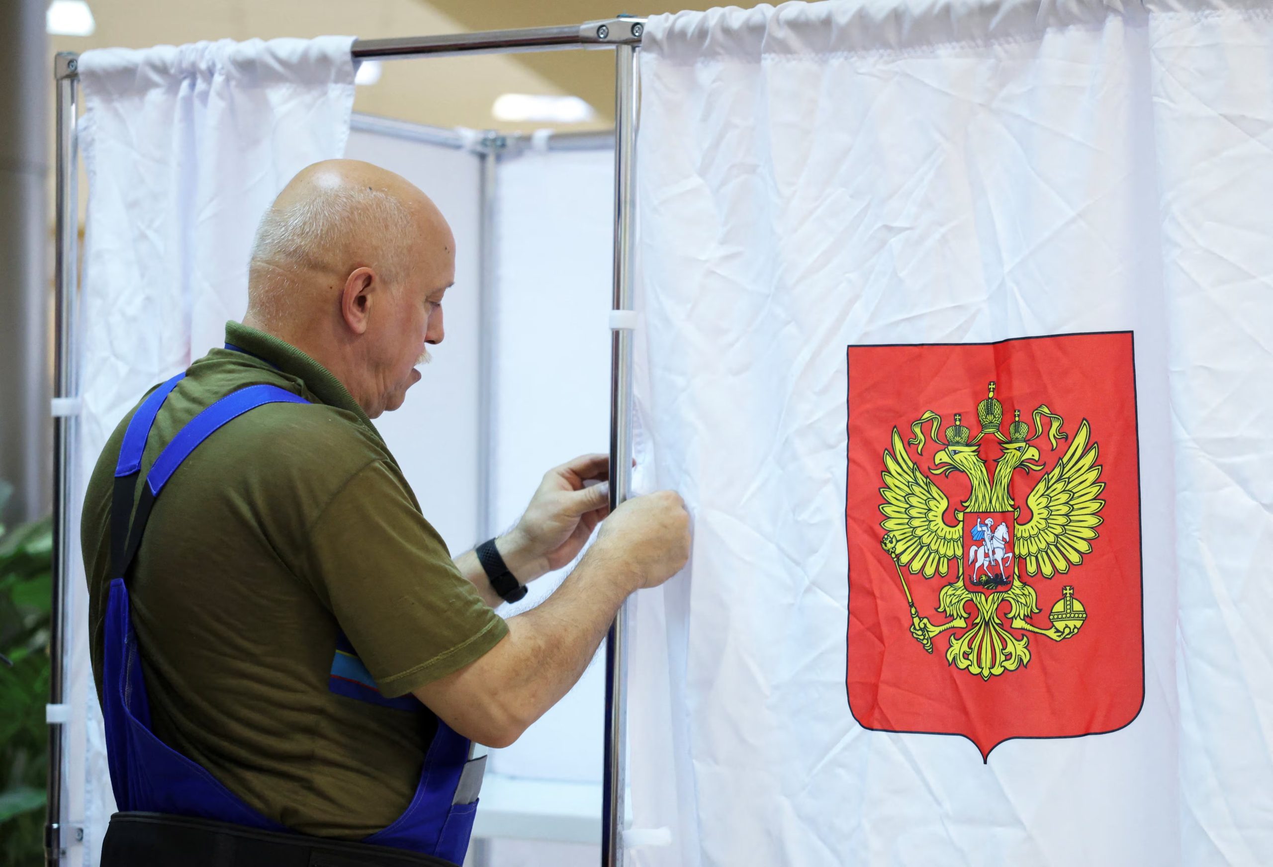 Un trabajador prepara un cuarto oscuro en un centro de votación en Podolsk, antes de las legislativas que Rusia Unida retendrá pese a que las encuestas independientes le dan apenas 20% de apoyo real. (REUTERS/Ramil Sitdikov)