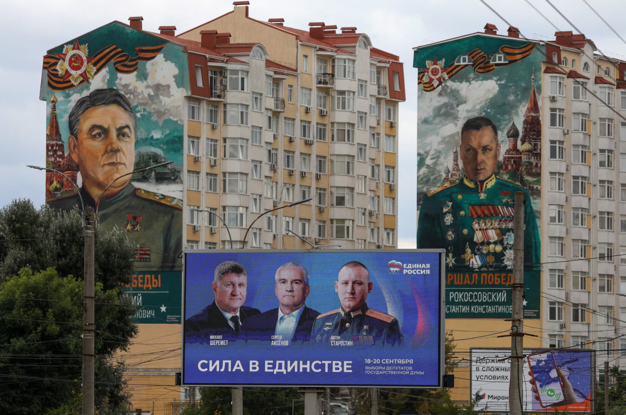 Una pantalla promociona a Rusia Unida en Simferopol, Crimea, junto a murales de comandantes soviéticos. El Kremlin buscó a toda costa evitar que la campaña se convirtiera en un debate sobre continuar la guerra o negociar la paz. (REUTERS/Alexey Pavlishak)