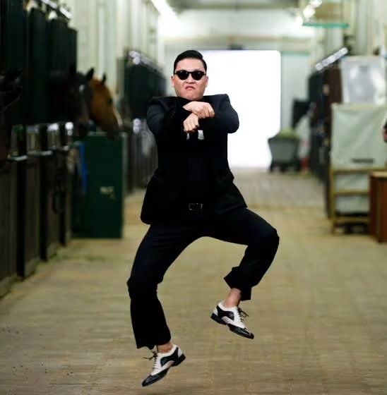 El músico surcoreano PSY realiza el baile de su canción Gangnam Style en el pasillo de un establo.