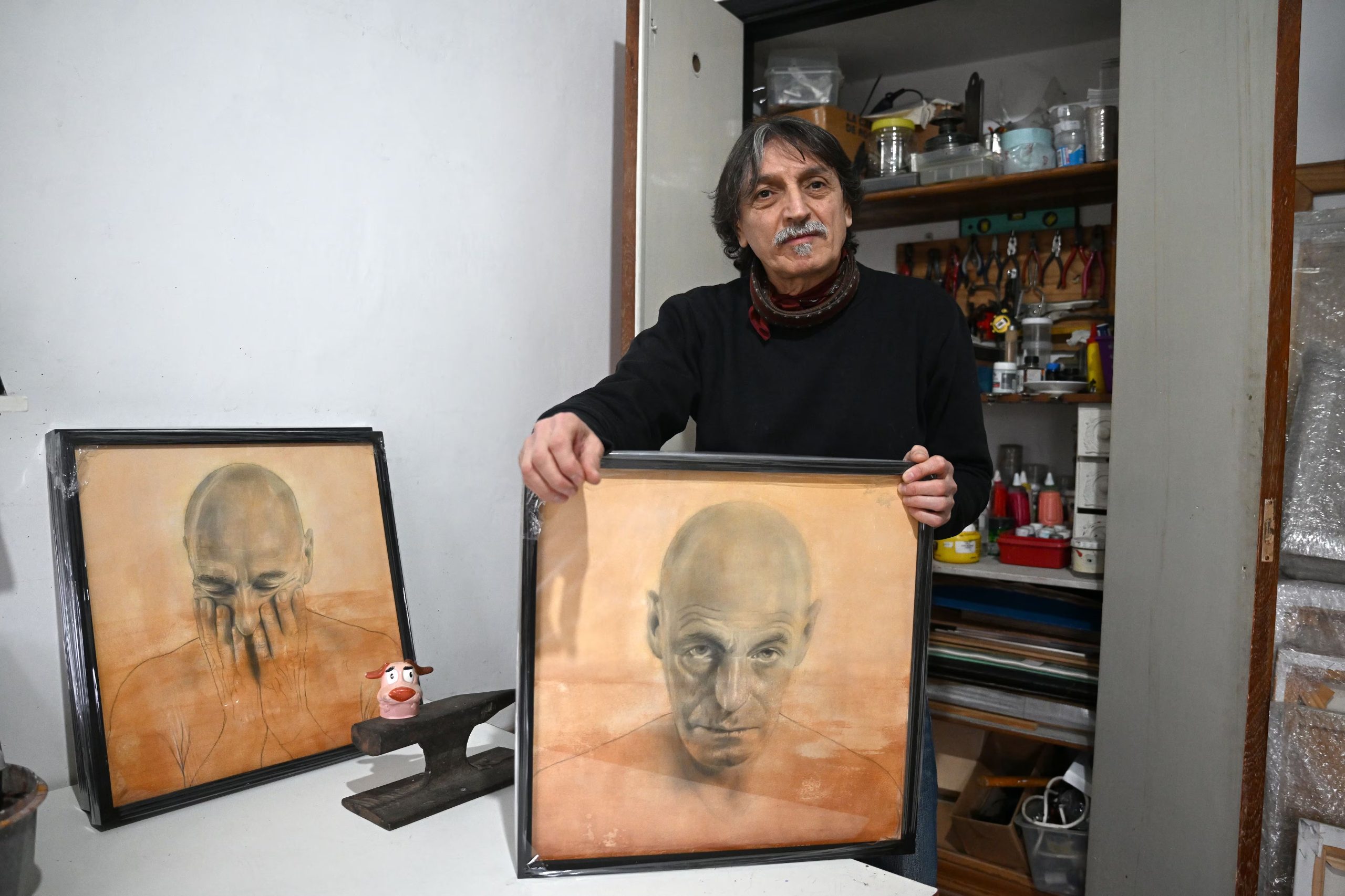 Santiago Raffo con parte de su producción artística en su casa/atelier en Saavedra. Hoy inaugura una muestra propia en Avellaneda con algunos de estos retratos. (Maximiliano Luna)