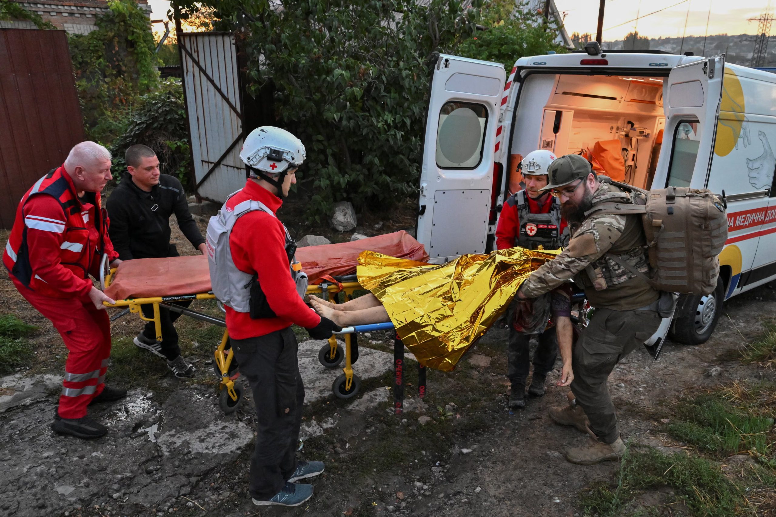 Paramédicos trasladan a una persona herida a una ambulancia en el lugar de viviendas particulares destruidas tras ser alcanzadas durante un ataque con drones rusos, en Zaporiyia (REUTERS/Stringer)

