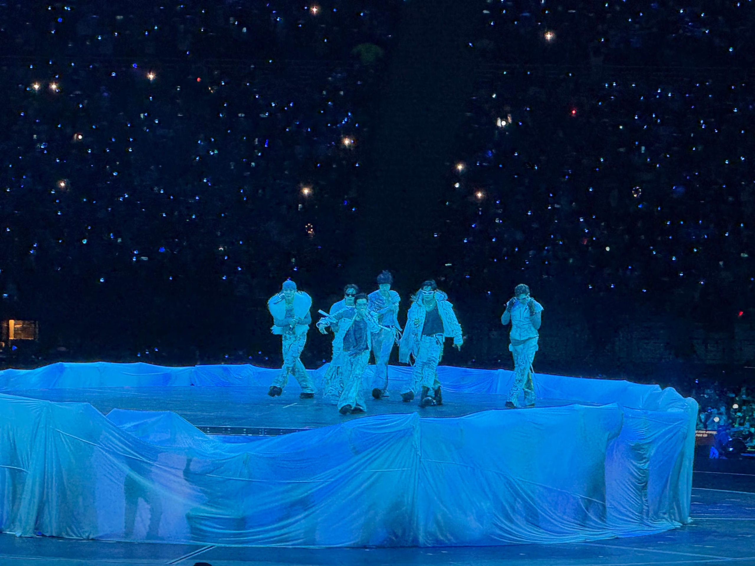 Los integrantes del grupo surcoreano BTS realizan una presentación sobre un escenario iluminado durante su concierto en el Estadio San Marcos de Lima. (Paula Diaz)