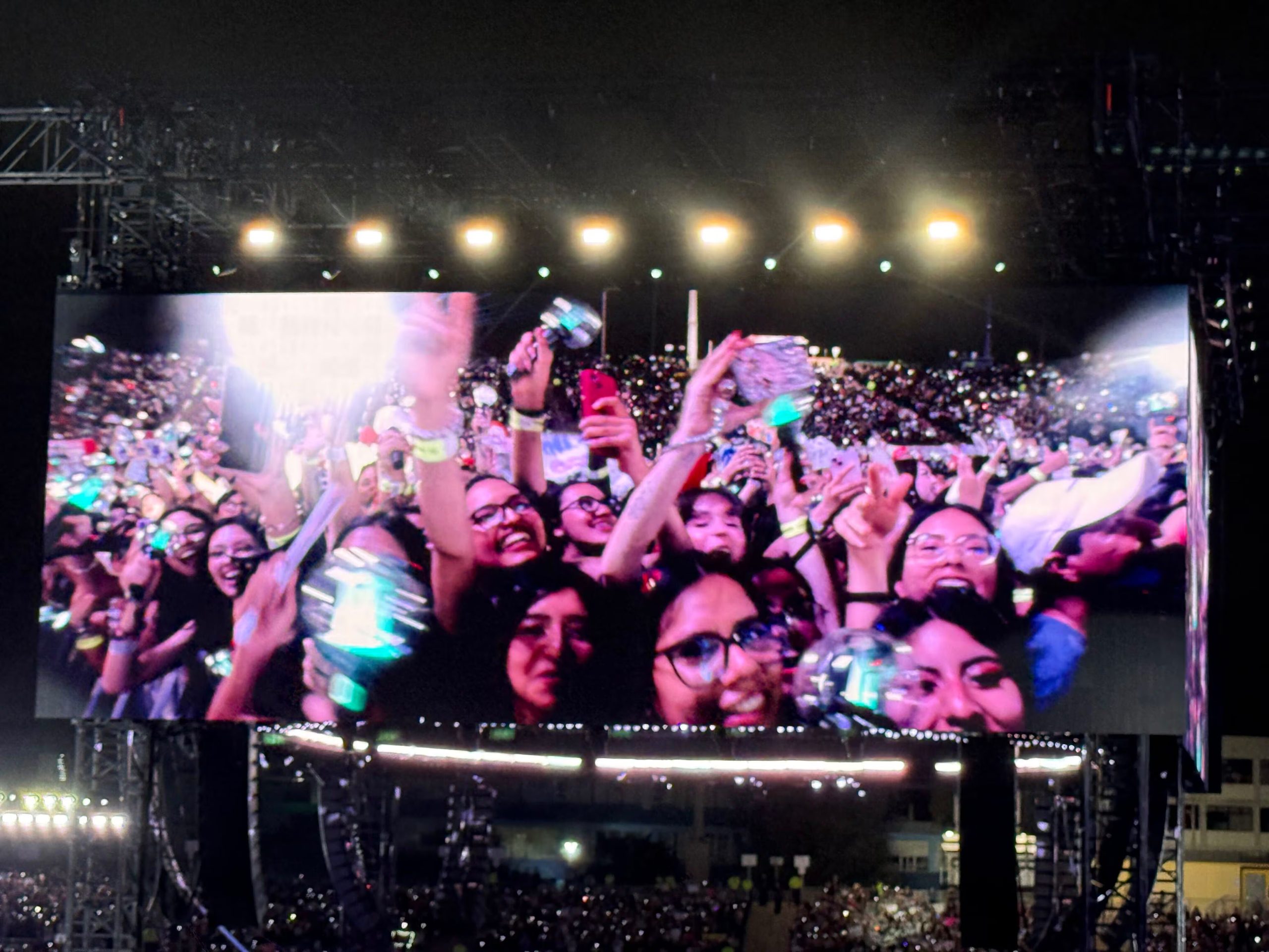Un grupo de fanáticos de BTS sostiene bastones de luz y teléfonos durante un concierto en el Estadio San Marcos de Lima. (Paula Diaz)
