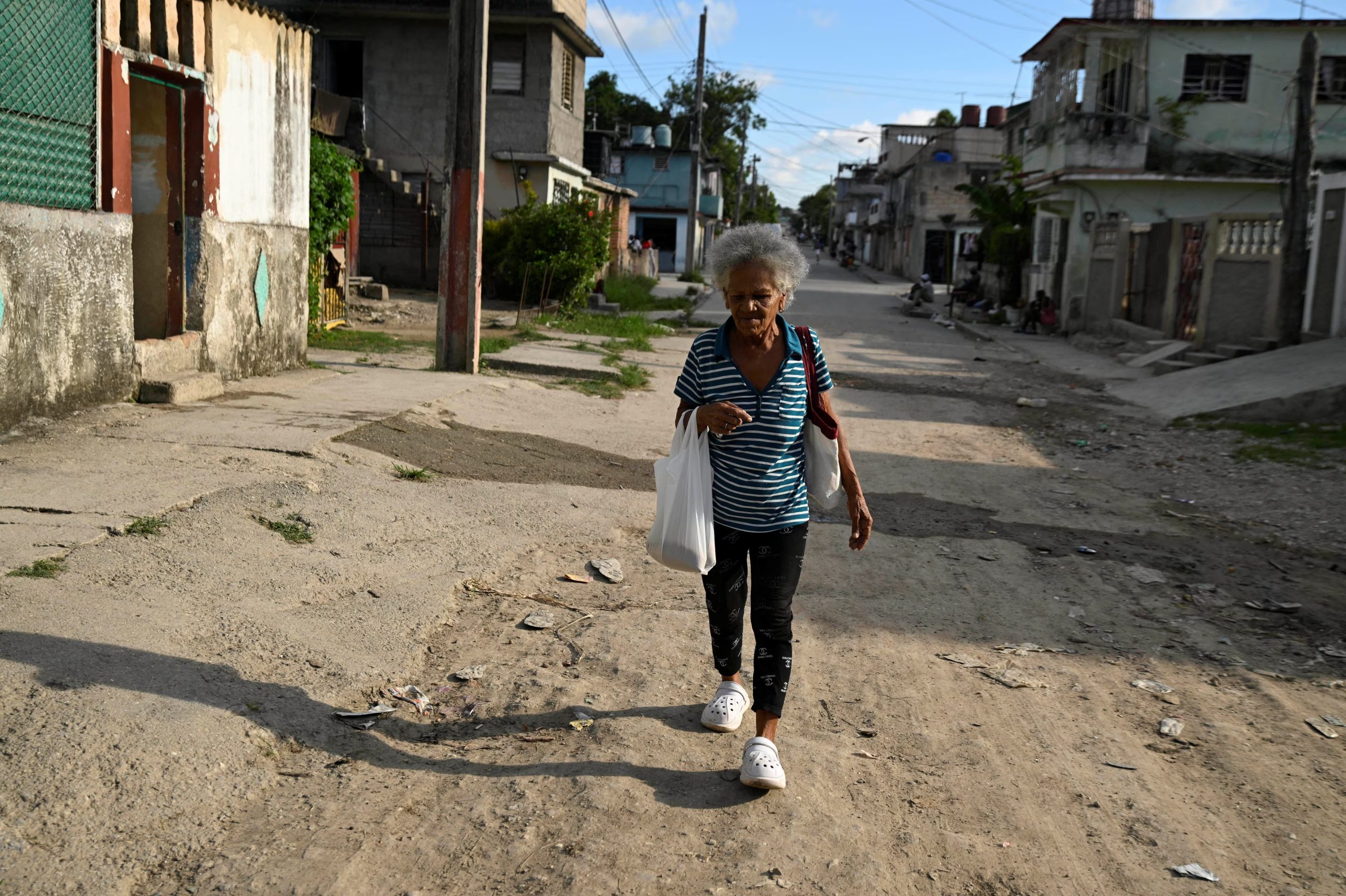 La pensionista Magda Navarro, de 71 años, camina por la calle tras salir de una tienda de comestibles en La Habana, Cuba, el 19 de agosto de 2025. REUTERS/Norlys Pérez
