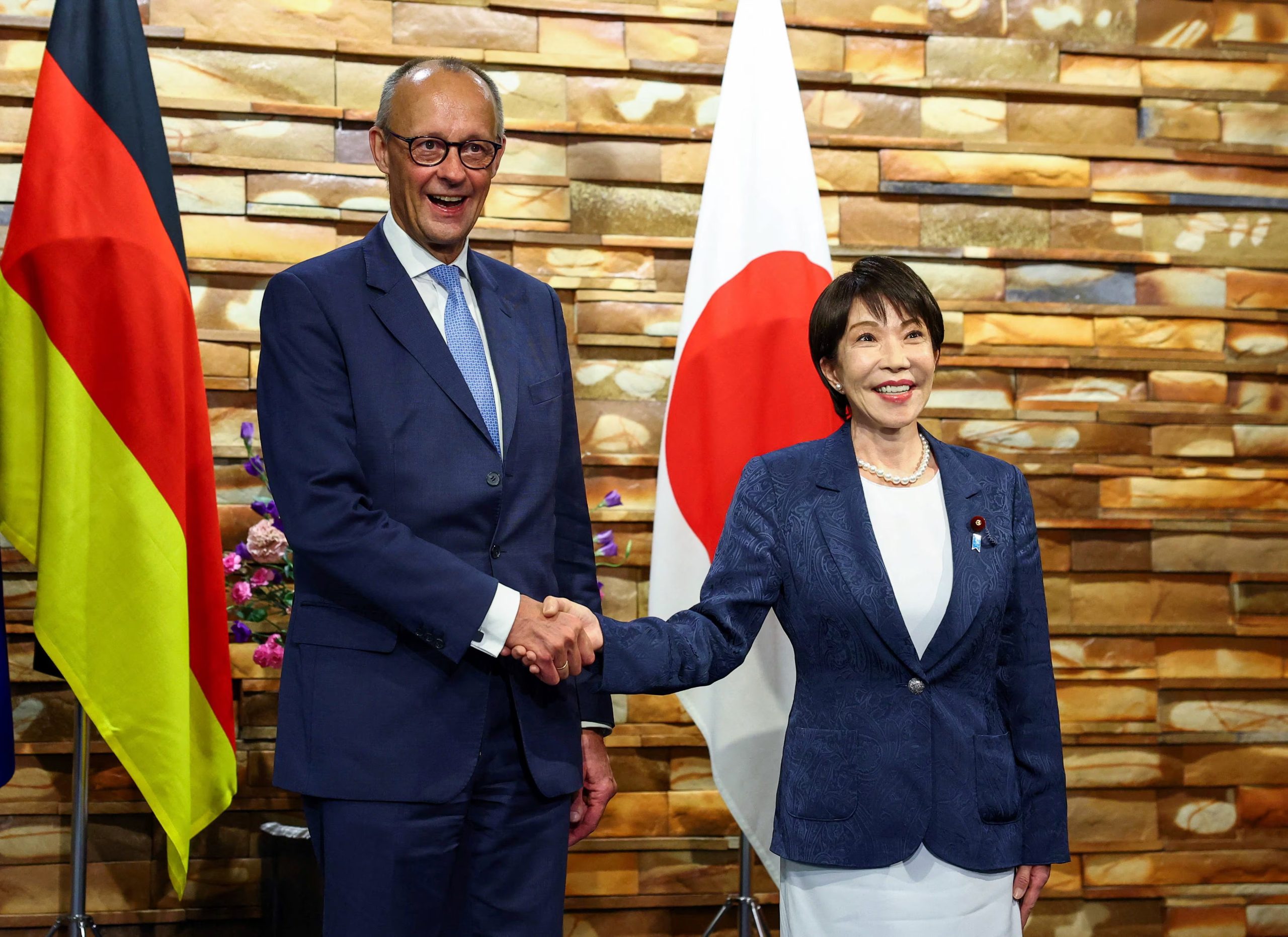El canciller alemán, Friedrich Merz (izq), estrecha la mano de la primera ministra japonesa, Sanae Takaichi, antes de su reunión en Tokio, Japón. 28 octubre 2026 (REUTERS/Issei Kato)
