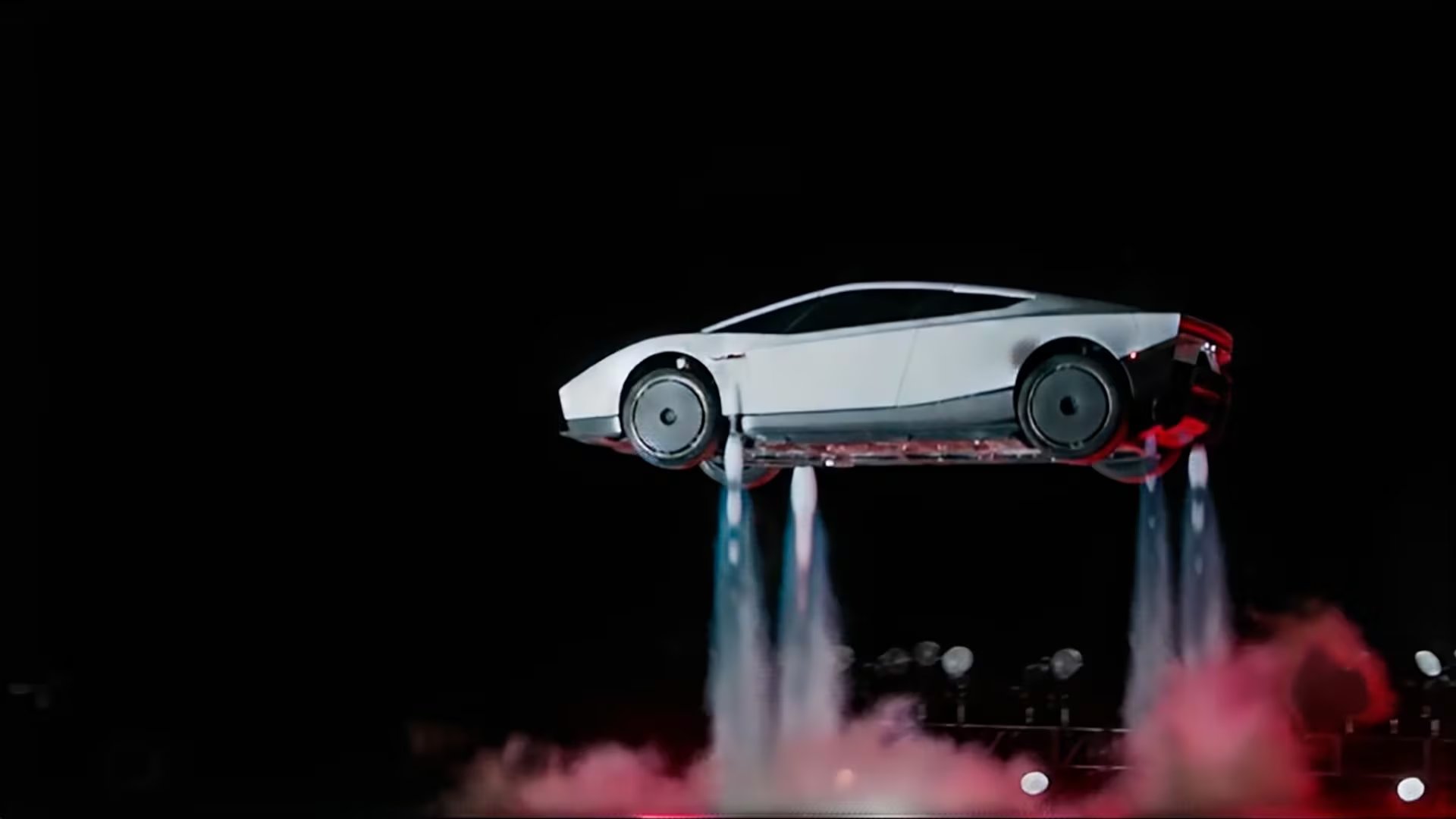 El automóvil eléctrico Tesla Roadster se eleva sobre un escenario mediante un sistema de propulsores verticales controlados por inteligencia artificial.