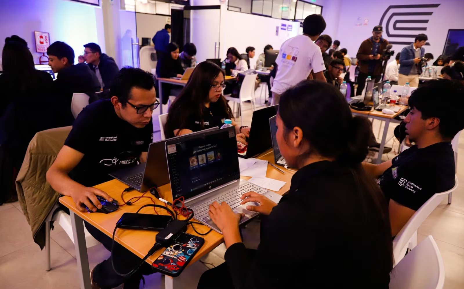 Varios participantes trabajan en equipos con computadoras portátiles durante una jornada presencial del NASA Space Apps Challenge en una sede de Perú.