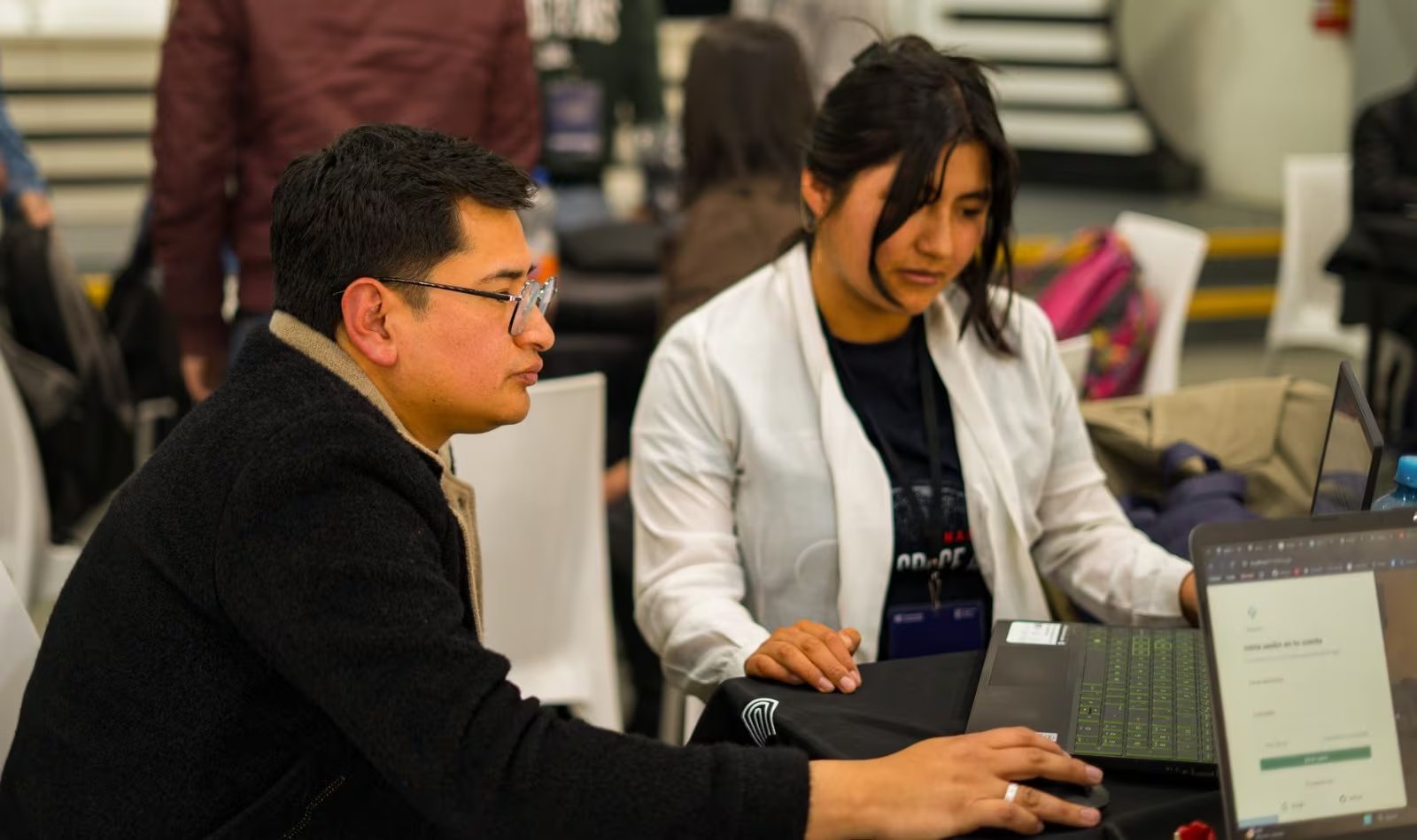 Dos participantes trabajan frente a una computadora portátil durante una de las actividades del certamen científico NASA International Space Apps Challenge en Perú.