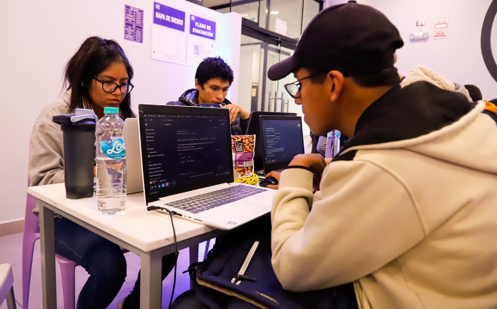 Un grupo de jóvenes trabaja con computadoras portátiles durante una jornada del certamen tecnológico NASA Space Apps Challenge en Perú.