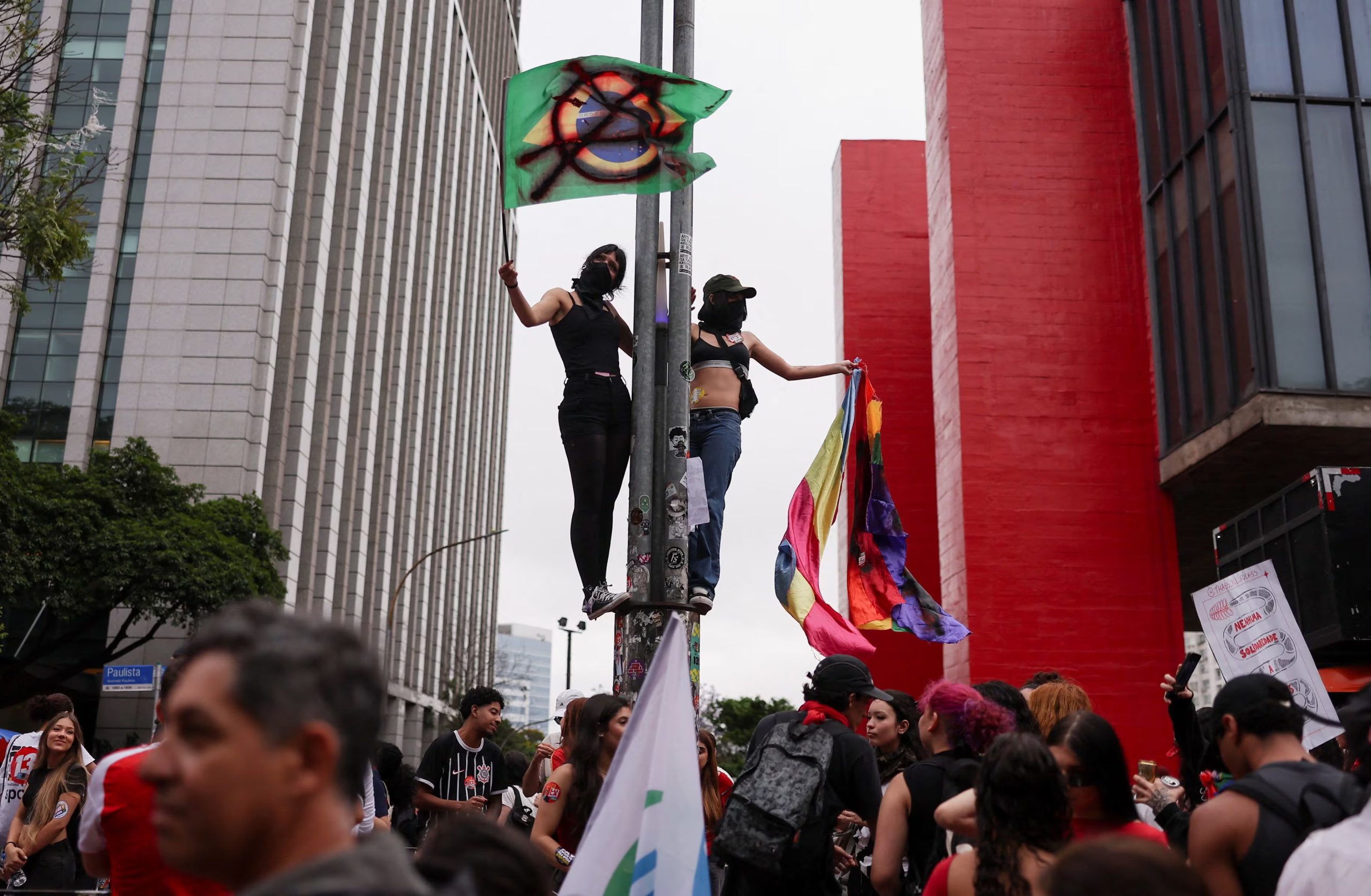 Partidarios del presidente brasileño Luiz Inácio Lula da Silva se suben a un poste y sostienen banderas durante una manifestación en San Pablo (REUTERS/Amanda Perobelli)
