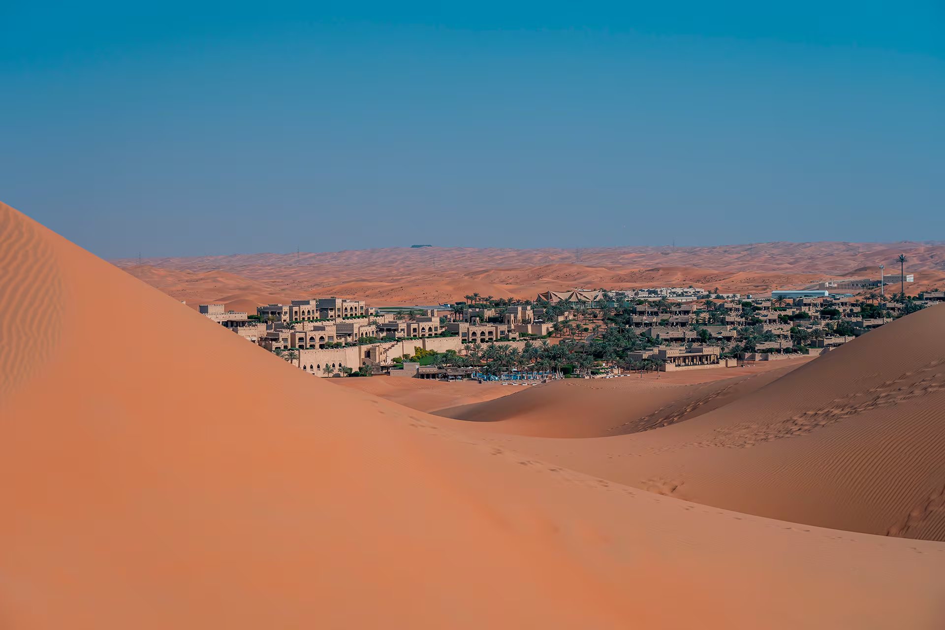 El Oasis de Liwa alberga vegetación y edificaciones entre las dunas de arena del desierto de Rub al-Jali en Abu Dabi, Emiratos Árabes Unidos. (Pexels)