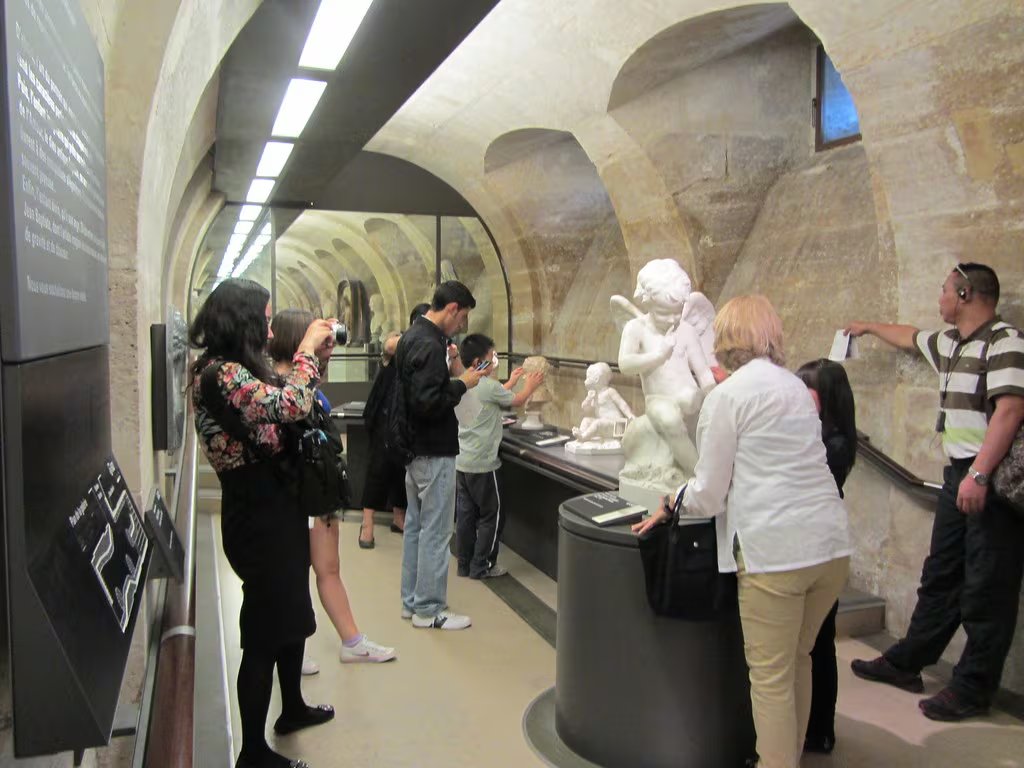 Un grupo de personas recorre la galería adaptada con esculturas e itinerarios táctiles en el Museo del Louvre