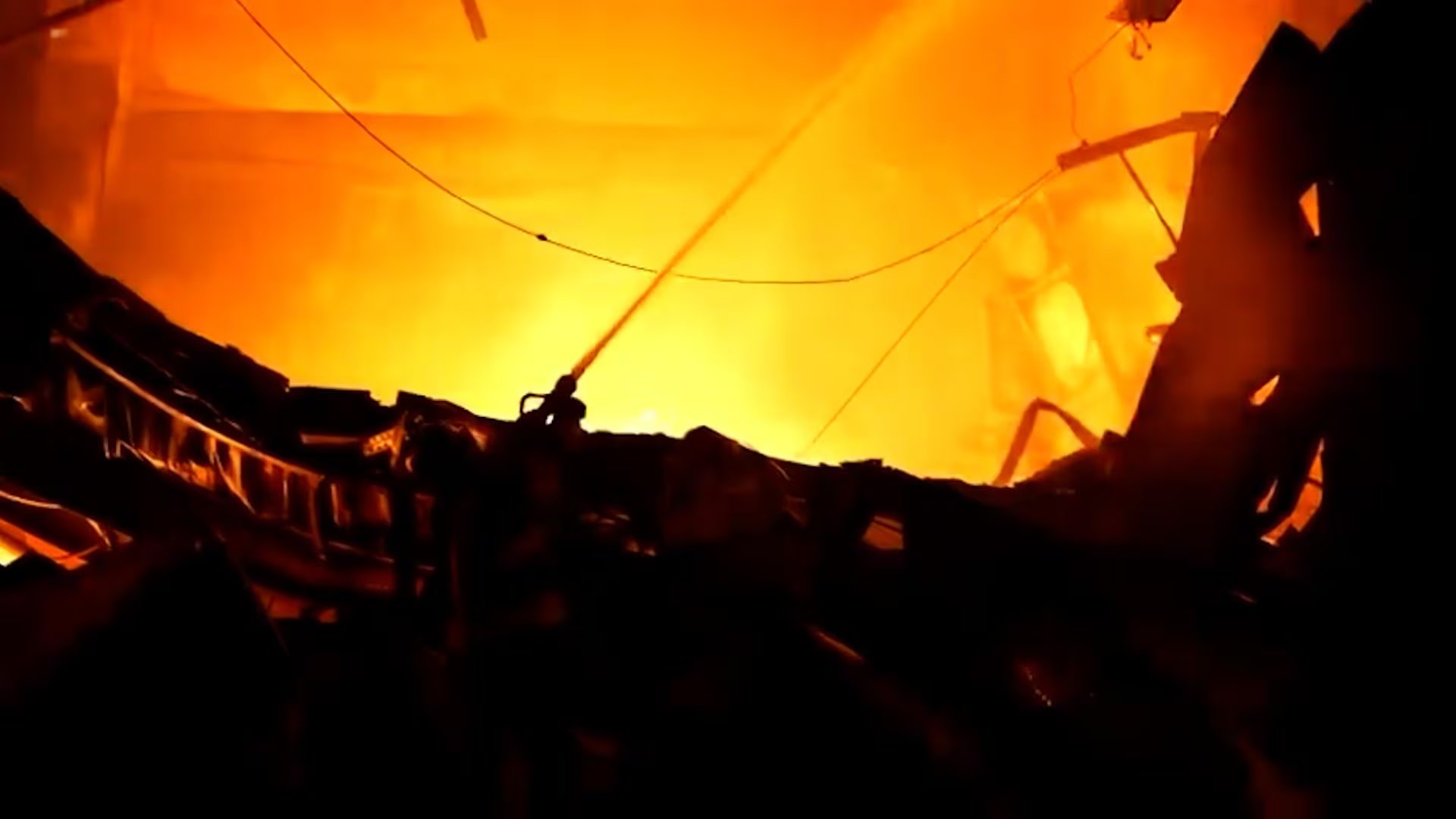 Los bomberos arrojan agua para sofocar las llamas entre las estructuras destruidas tras una serie de ataques rusos en territorio ucraniano